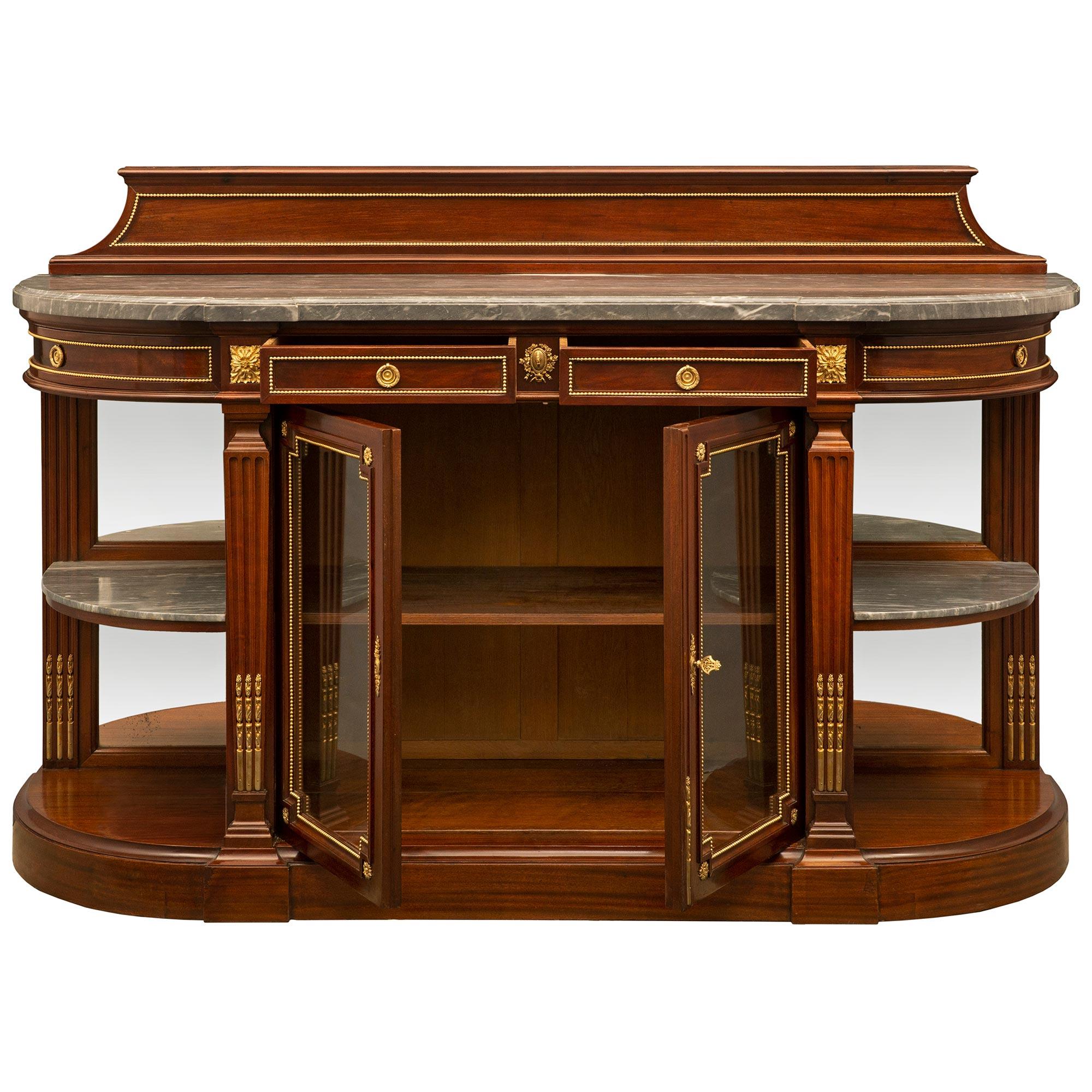 Superbe buffet français du milieu du XIXe siècle en acajou de style Louis XVI. Le buffet repose sur une base en demi-lune avec quatre colonnes effilées en roseau avec des chandelles en bronze doré soutenant la frise. Deux portes centrales en acajou