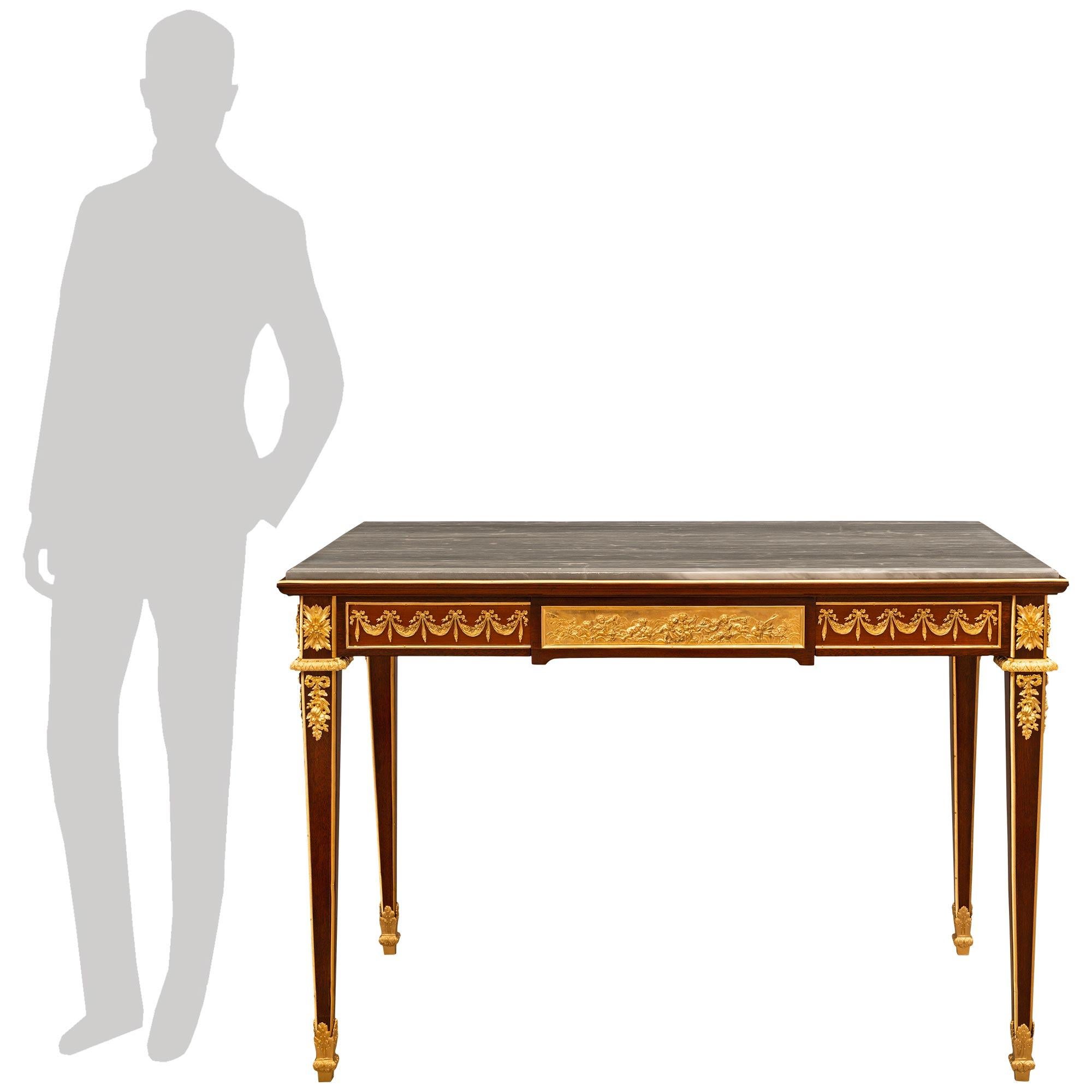 A stunning and most decorative French 19th century Louis XVI st. Mahogany, Ormolu, and Gris St. Anne marble center table/desk, attributed to François Linke. This wonderful single drawer rectangular center table is raised on four square tapered legs