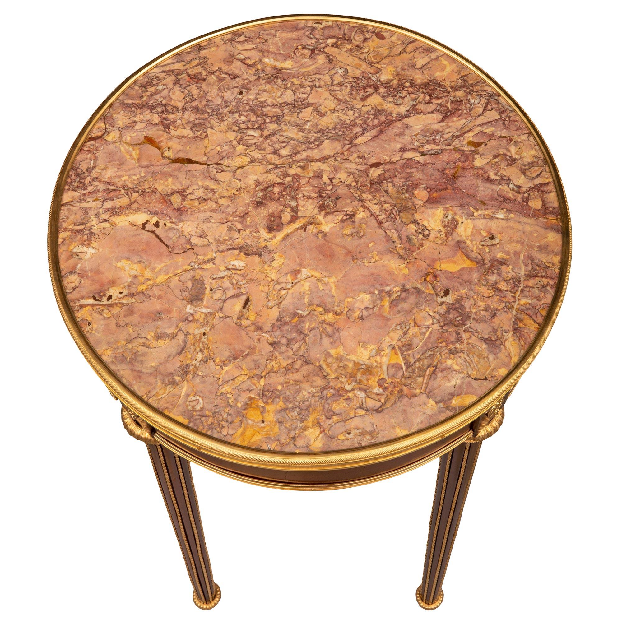 Remarquable table d'appoint circulaire de très grande qualité, de style Louis XVI, en acajou, bronze doré et marbre Brocatelle Violette. La table circulaire est surélevée par d'élégants pieds circulaires effilés avec de fins pieds en forme de topie