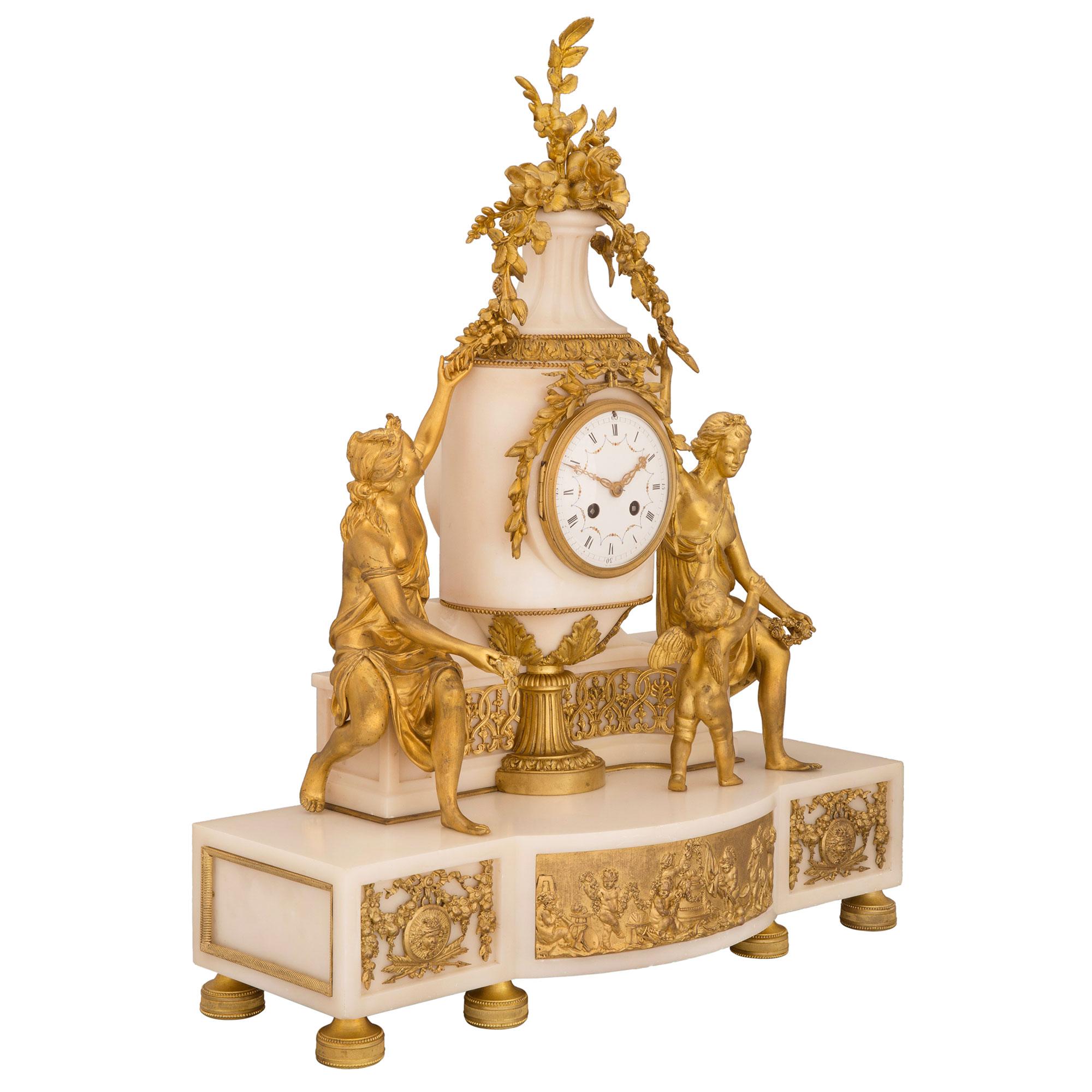 A spectacular French 19th century Louis XVI st. white Carrara marble and ormolu clock, signed Samuel Marti. The clock is raised by six beautiful circular ormolu feet with fine fluted and beaded designs. The white Carrara marble base displays a most