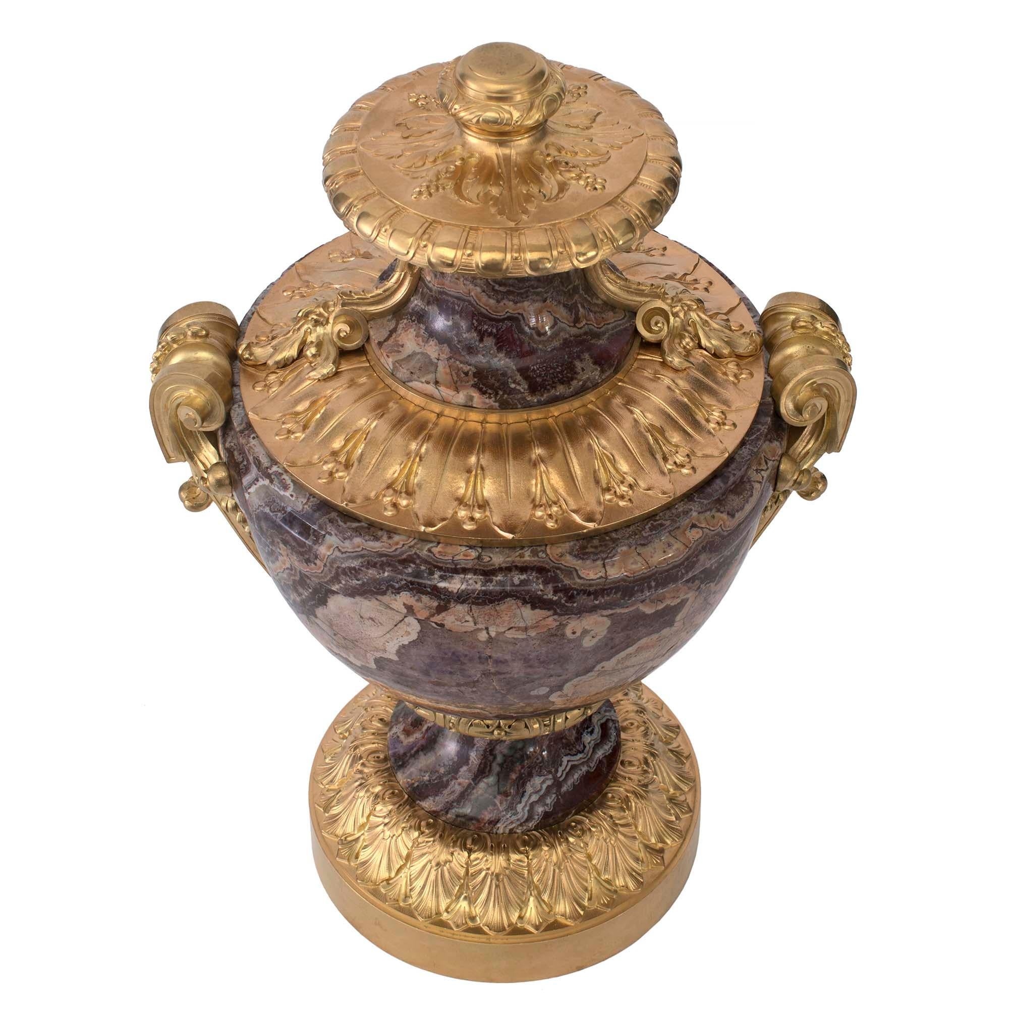 A stunning and impressive French 19th century Louis XVI st. marble and ormolu lidded urn. The urn is raised on a circular base decorated with acanthus leaves and an ormolu band above the marble socle. Flanking the marble body are scrolled handles