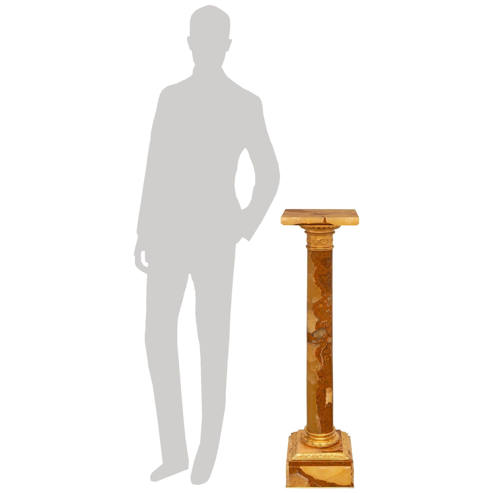 Colonna con piedistallo in onice e ormolu di grande effetto ed estremamente elegante, risalente al XIX secolo, in stile Luigi XVI. Questo splendido piedistallo è sollevato da una base quadrata in Onice con un design a gradini e decorato con una