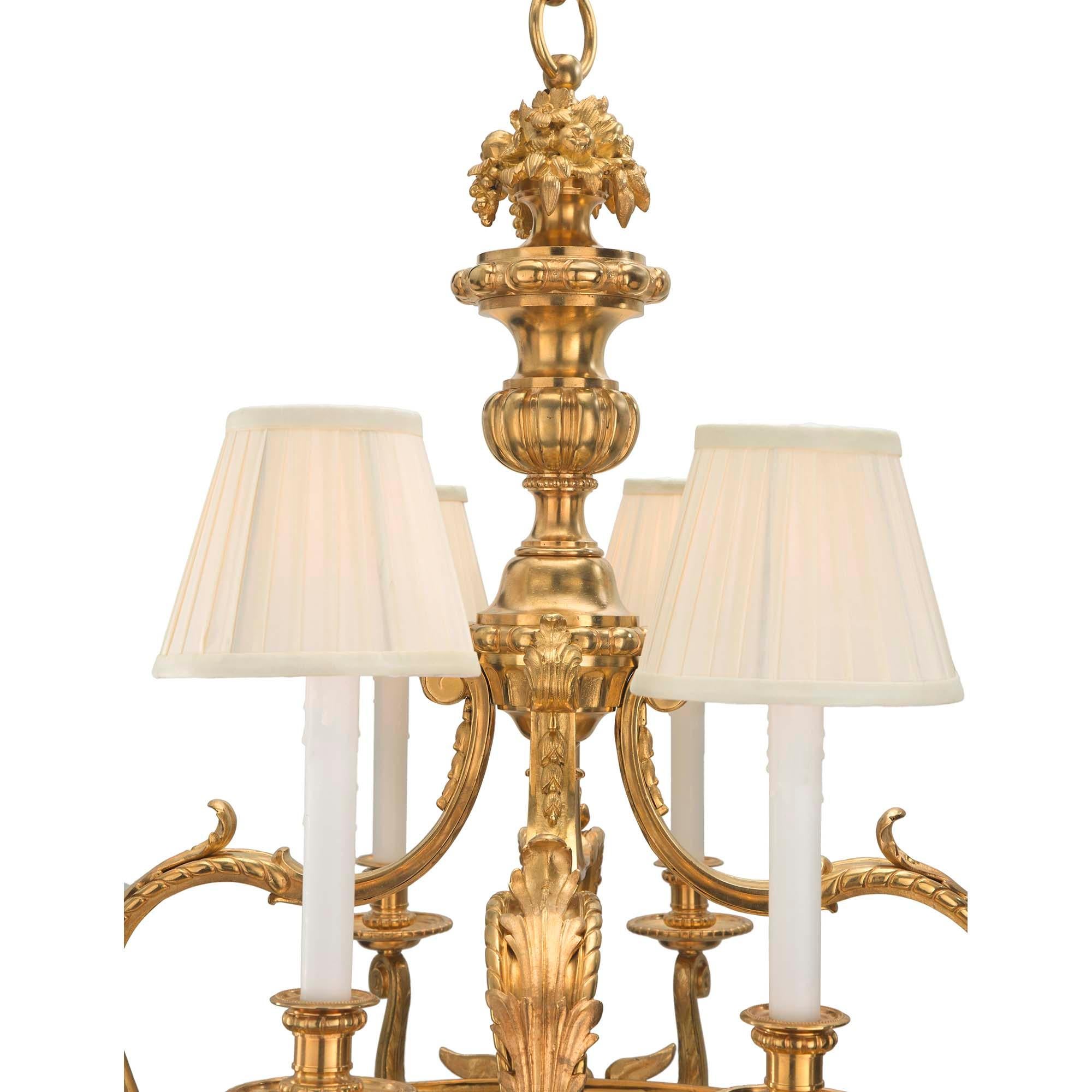 A stunning French 19th century Louis XVI st. ormolu and alabaster eight arm fourteen light chandelier. The chandelier is centered by a fine foliate finial below the impressive alabaster dome which houses six light bulbs offering a warm glow