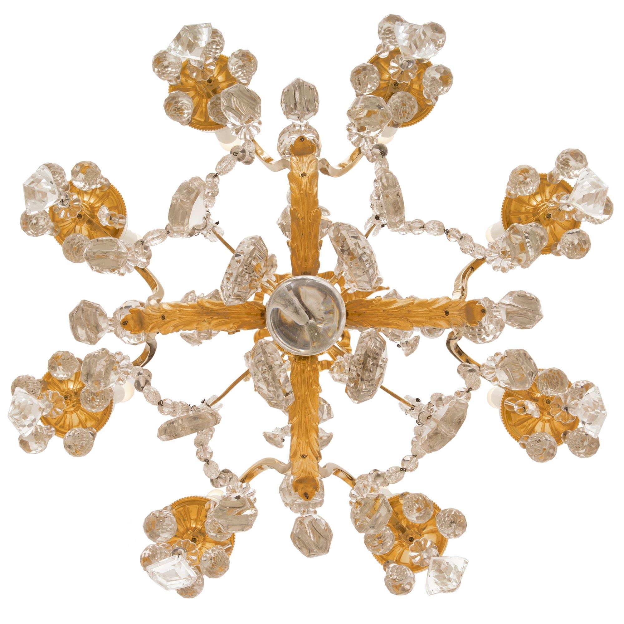 An exceptional and unique French 19th century Louis XVI st. ormolu and Baccarat crystal chandelier. The eight arm chandelier is centered by a beautiful solid crystal ball pendant below a fine foliate ormolu finial surrounded by lovely faceted cut