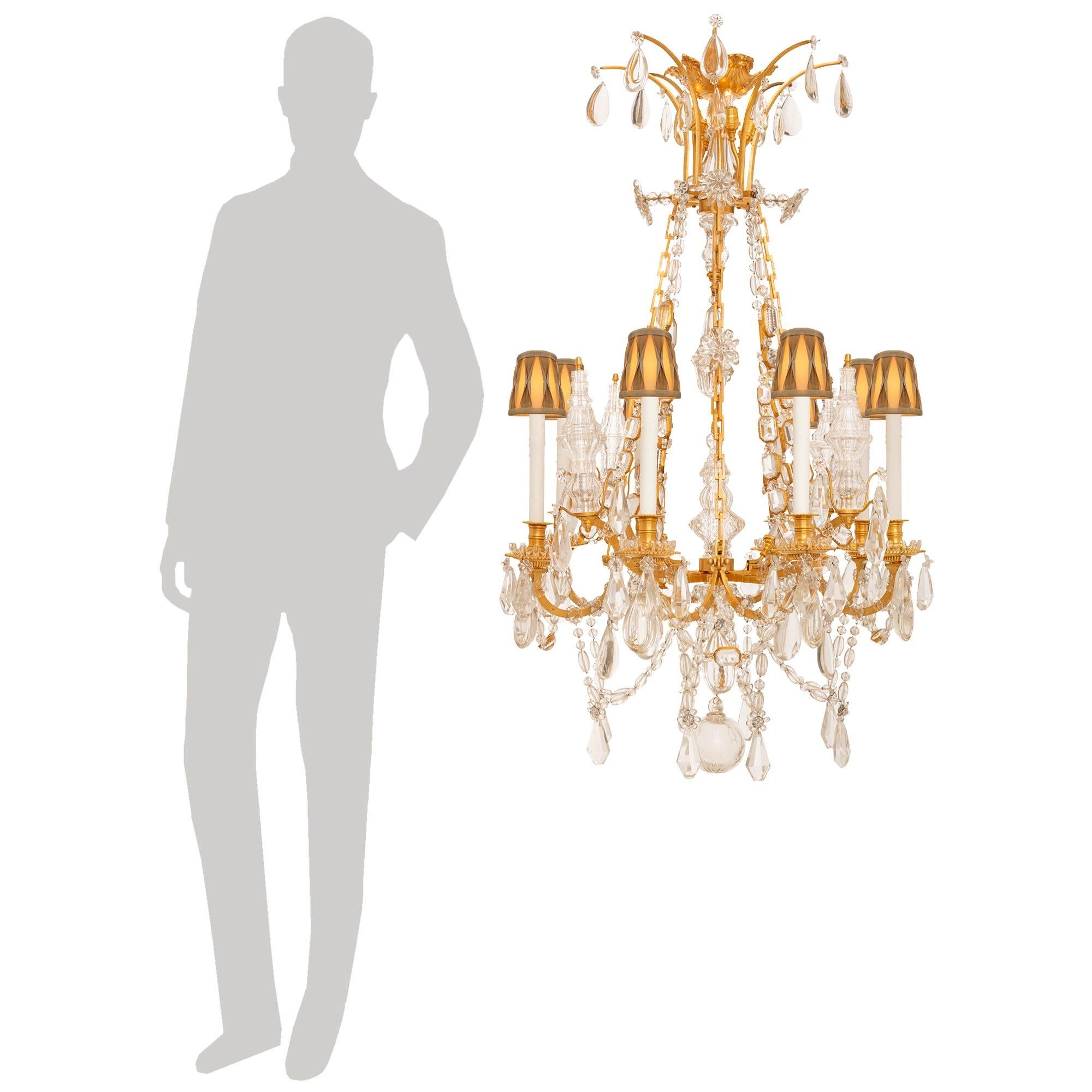 A spectacular and extremely high quality French 19th century Louis XVI st. Ormolu and Baccarat Crystal Marie Antoinette chandelier. This fantastic eight arm twenty light chandelier is centered by a Baccarat Crystal ball with a sunburst cut at its