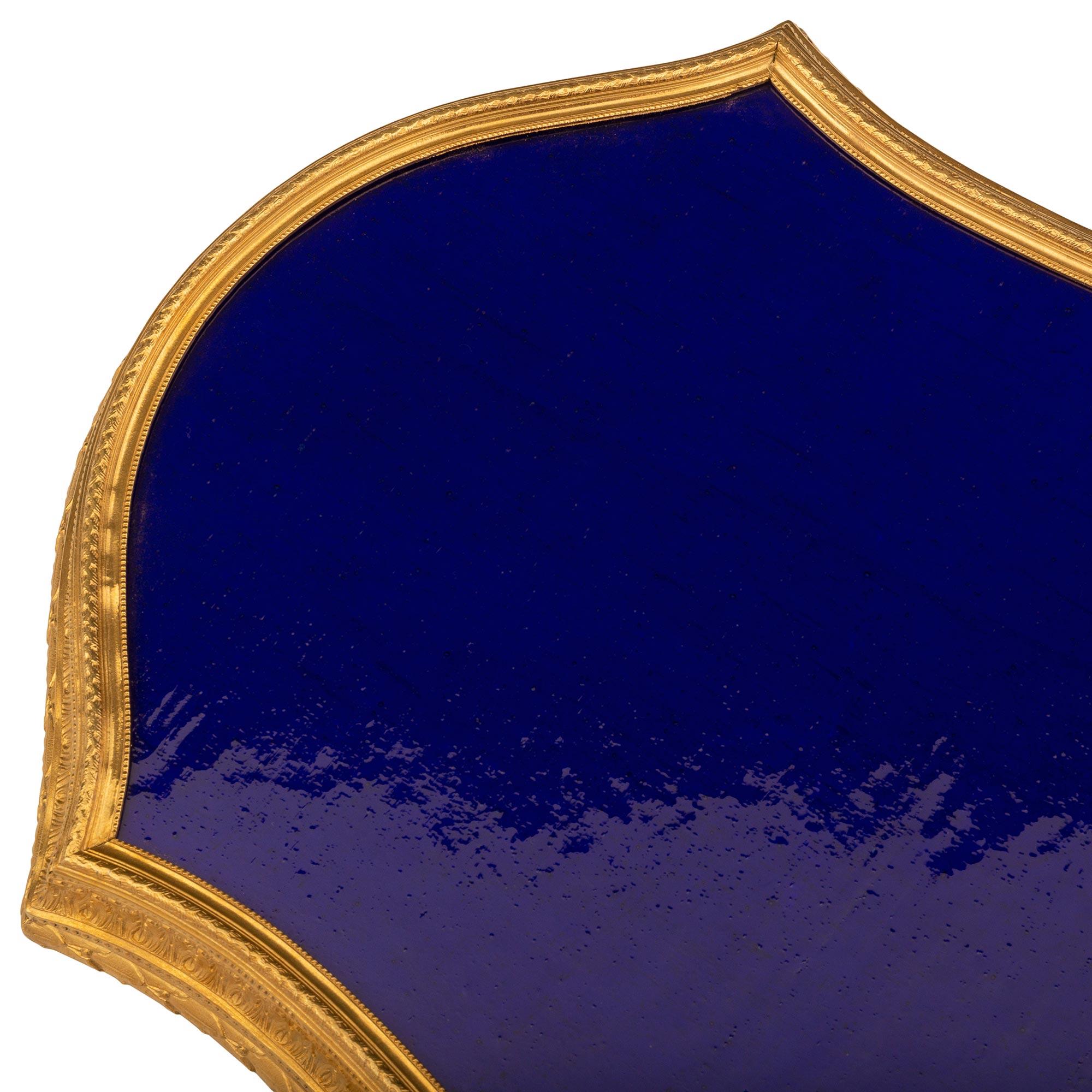 A striking and most elegant French 19th century Louis XVI st. ormolu and cobalt blue glass centerpiece plateau. The plateau is raised by a beautiful mottled ormolu band with a lovely scalloped shape and displaying richly chased berried laurel,