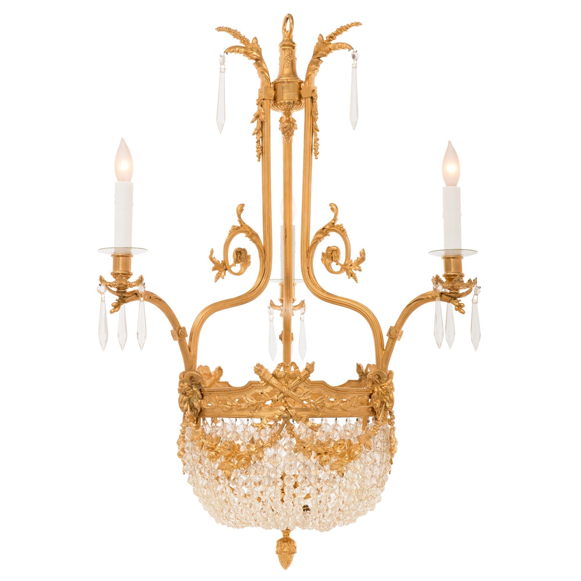 A beautiful and unique French 19th century Louis XVI st. ormolu and crystal chandelier. The three arm six light chandelier is centered by a charming finely detailed bottom acorn finial below most decorative balloon shaped beaded crystal garlands.