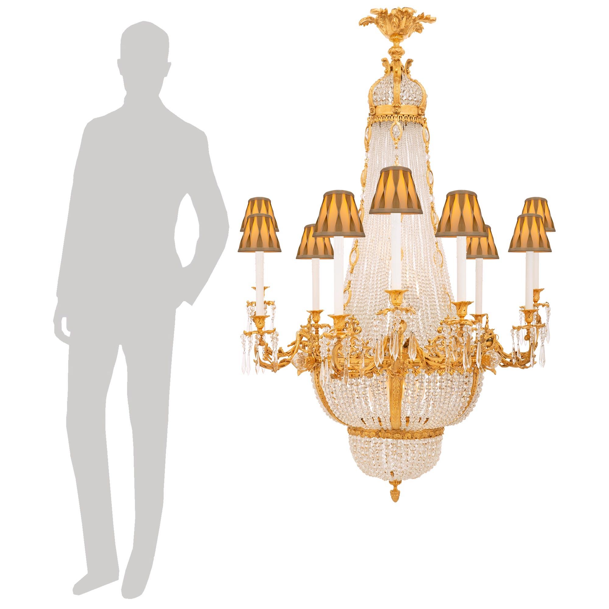Un imponente lampadario francese del XIX secolo St. Louis Crystal e ormolu di alta qualità. Questo splendido lampadario a nove bracci e venti luci a forma di Montgolfière è centrato da un terminale inferiore a ghianda che si trova al di sotto di uno