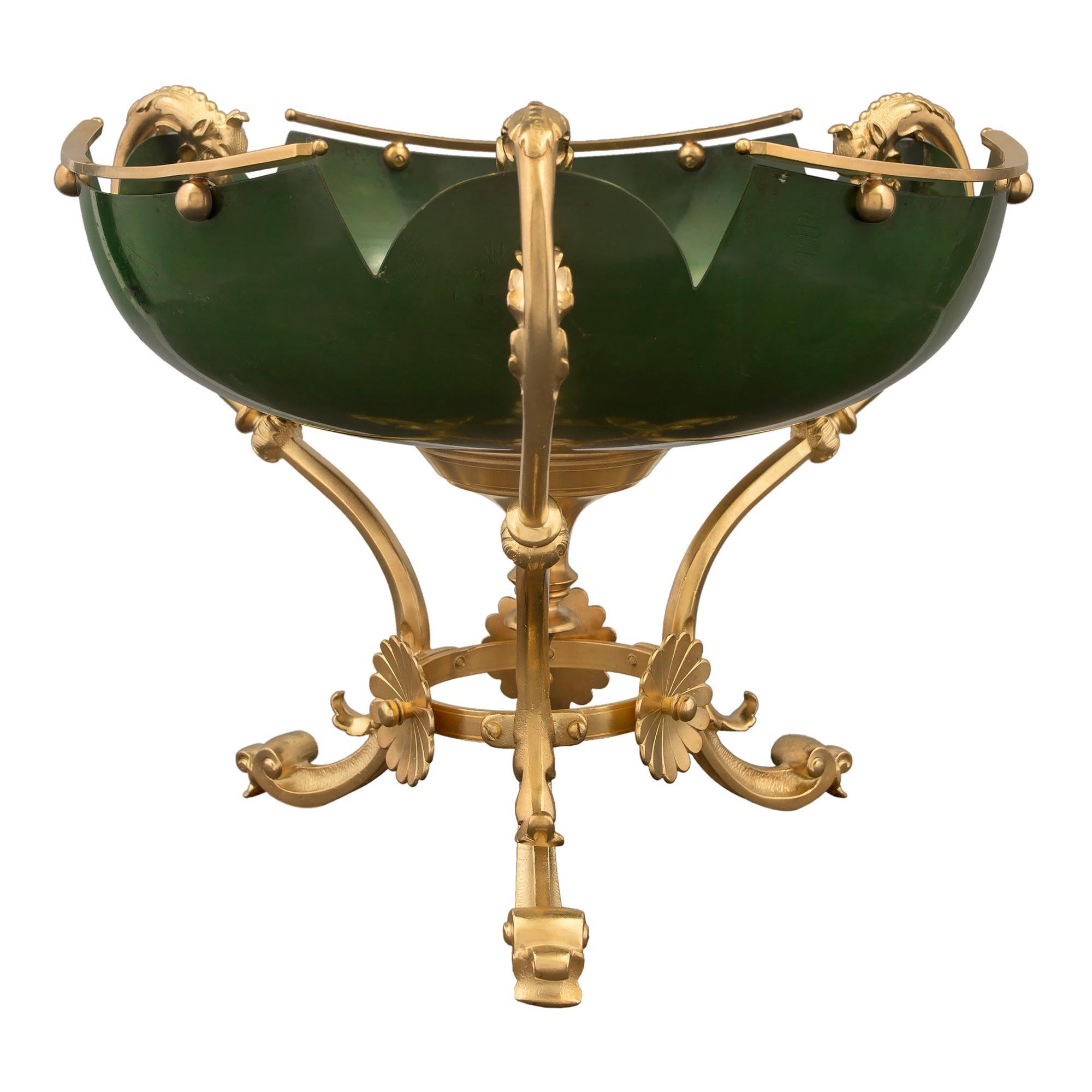 A striking and most uniquely shaped French 19th century Louis XVI st. ormolu and enamel centerpiece. The centerpiece is raised by three elegant scrolled ormolu supports, with fine foliate designs and a circular stretcher with beautiful floral