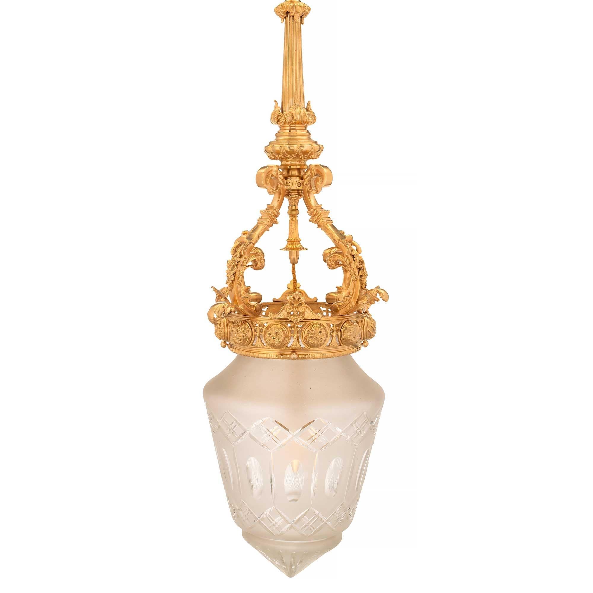 A beautiful French 19th century Louis XVI st. ormolu and frosted etched glass lantern. The lantern is centered by the elegant etched frosted glass housing which displays a fine sunburst design at the bottom and elegant interlocking and oval shapes.