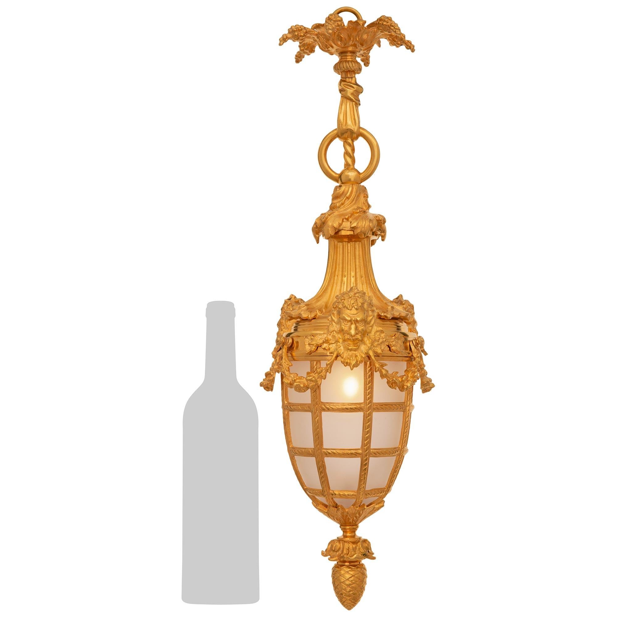 An elegant and most unique French 19th century Louis XVI st. Ormolu and frosted glass lantern. This wonderfully decorative lantern is decorated by a bottom inverted acorn finial. Above is a spiral fluted Ormolu mount that holds the original frosted