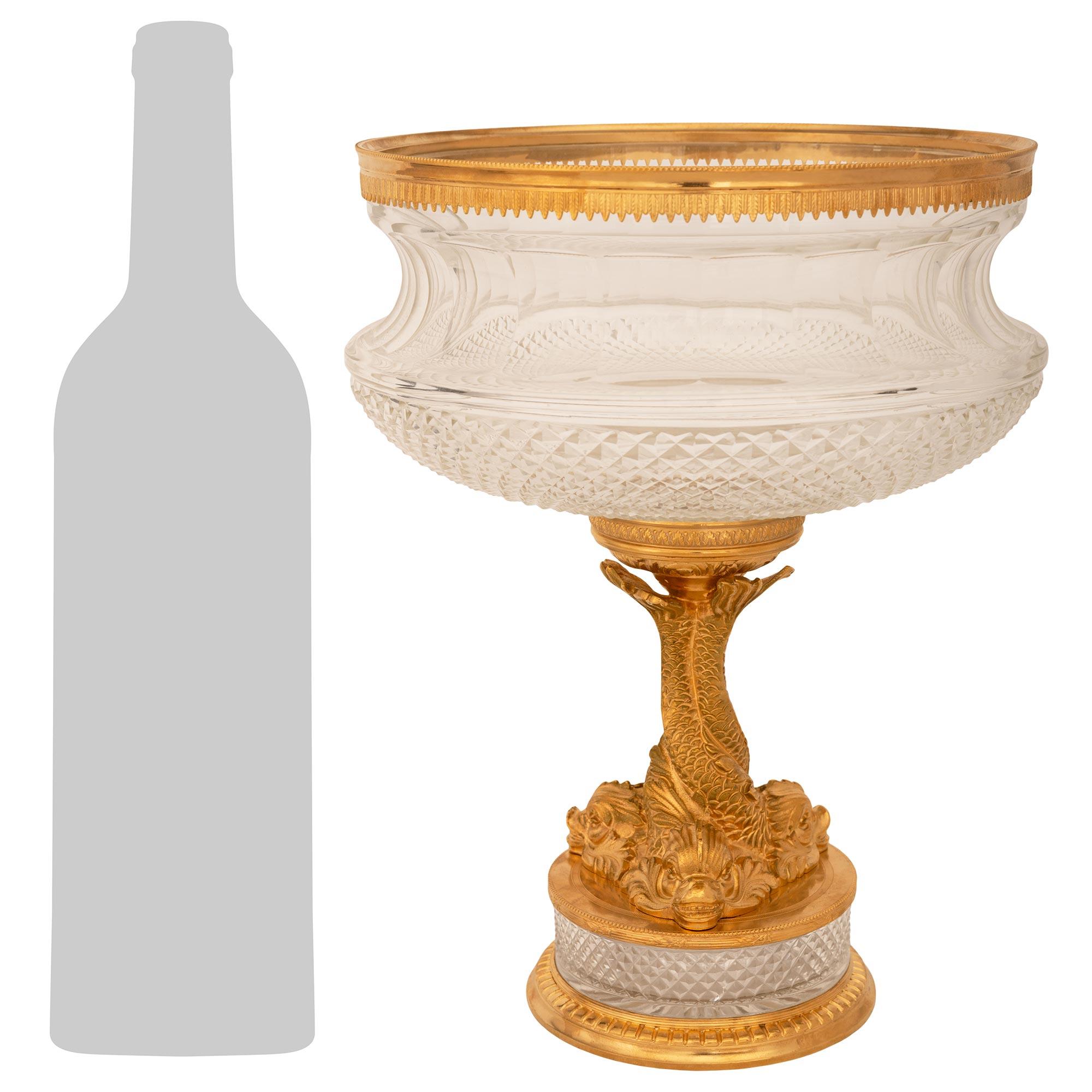 An elegant and high quality French 19th century Louis XVI st. Ormolu and Glass centerpiece. This attention grabbing centerpiece is raised by a lattice cut circular Glass pedestal supported on a dentil patterned Ormolu base with a mottled edge. Above