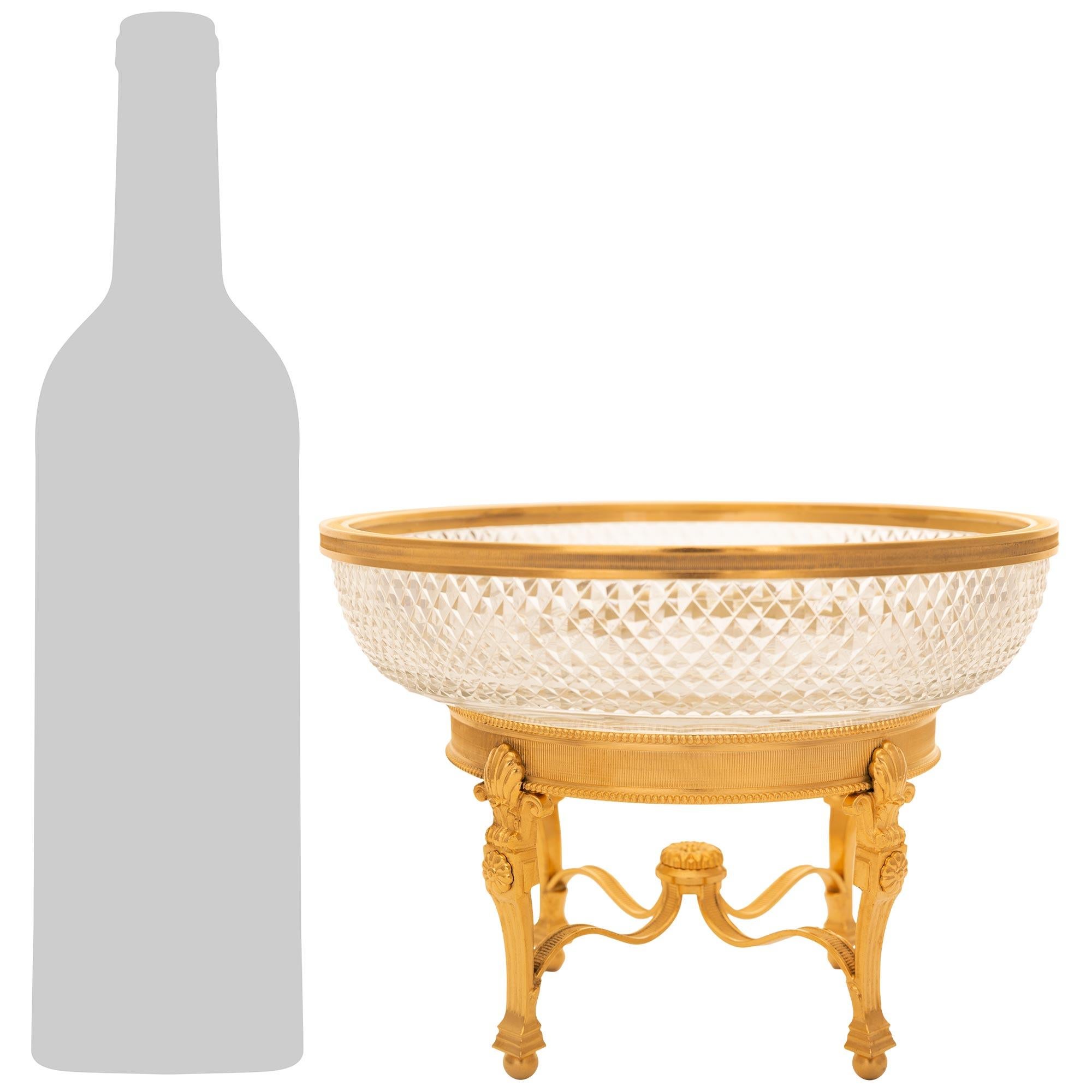 An elegant and high quality French 19th century Louis XVI st. Ormolu and Glass centerpiece. This stunning glass bowl is raised on an Ormolu base supported by four ball feet below mottled plinths and the fluted legs. A scrolled reeded Ormolu