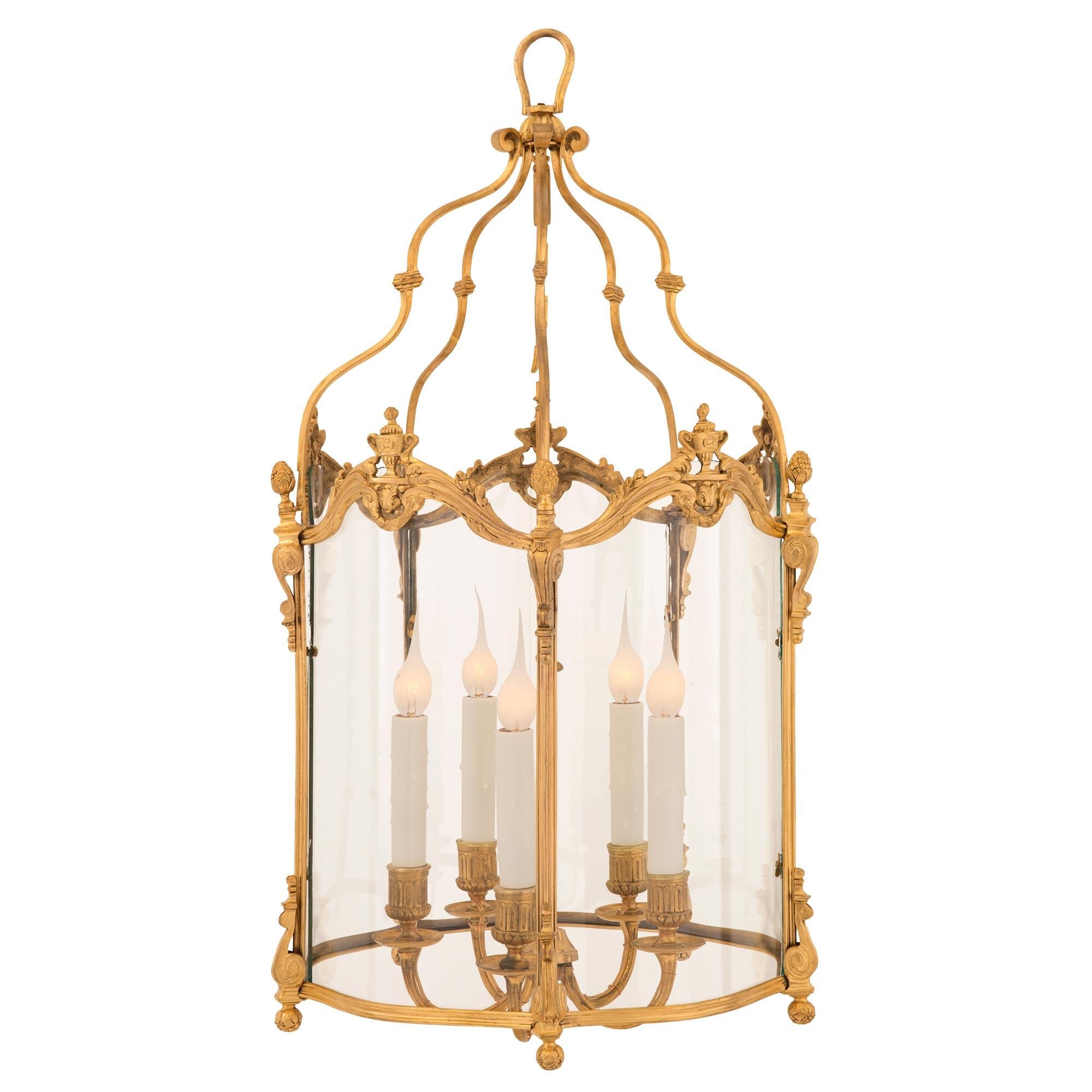 A beautiful French 19th century Louis XVI st. ormolu and glass lantern. The lantern displays five elegantly curved sides retaining their original hand blown glass panes with a lovely ormolu scalloped base and charming richly chased berried foliate