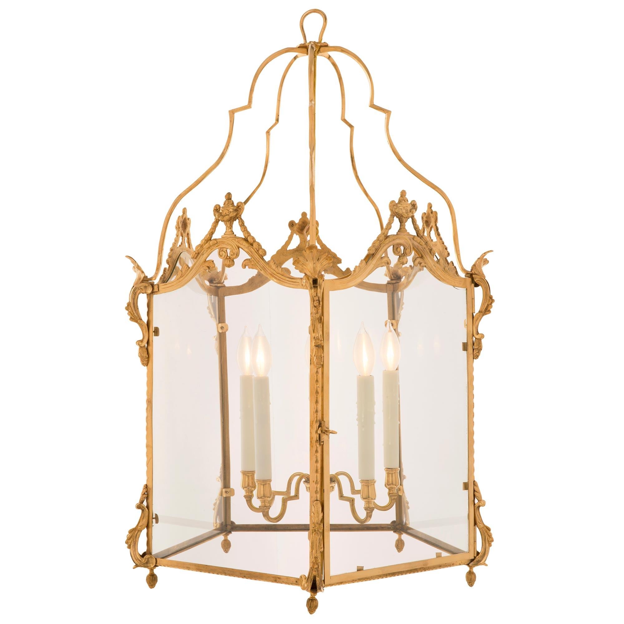 A remarkable French 19th century Louis XVI st. ormolu and glass lantern. The pentagonal shaped five light lantern displays charming richly chased bottom inverted acorn finials below lovely pierced scrolled foliate elements and a finely detailed band