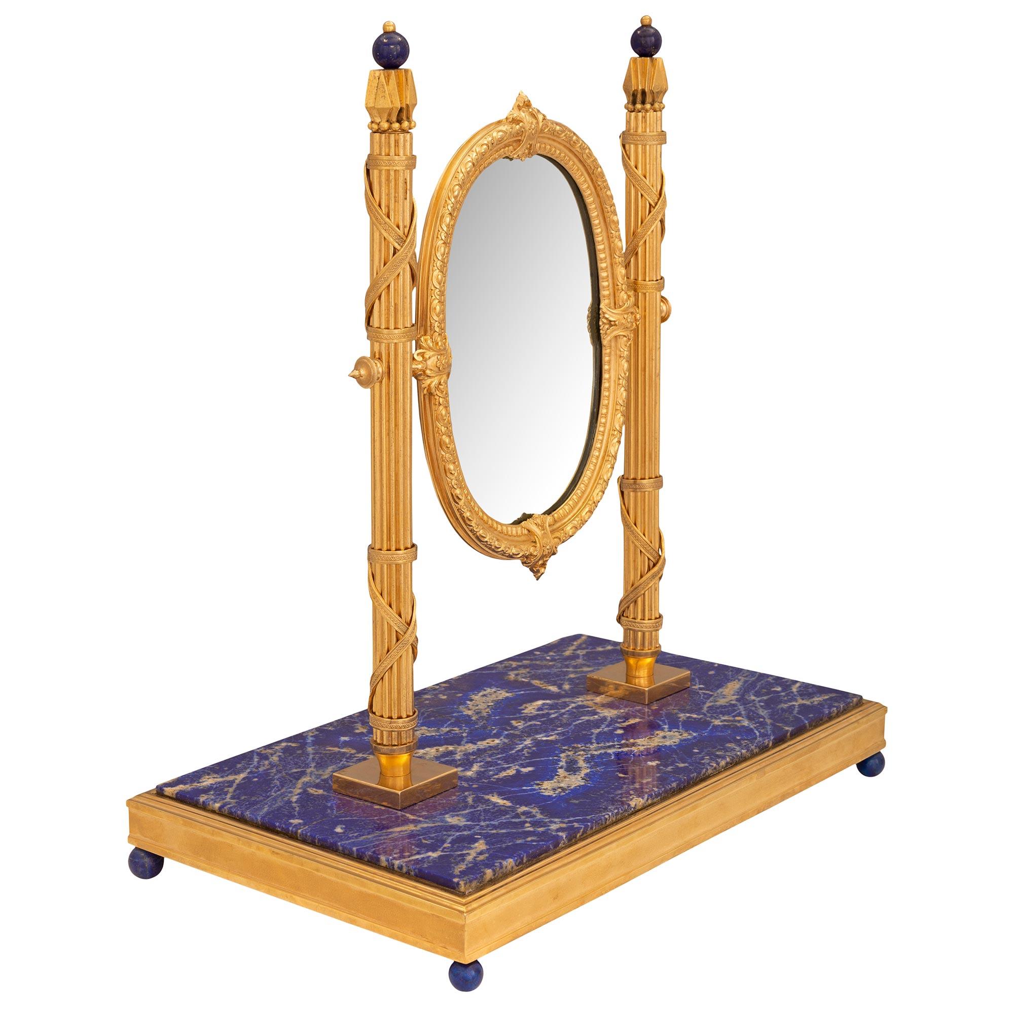 A stunning and very unique French 19th century Louis XVI st. Belle Époque period ormolu and Lapis Lazuli marble vanity mirror. The mirror is raised by elegant and extremely decorative Lapis Lazuli ball feet below the stunning rectangular Lapis