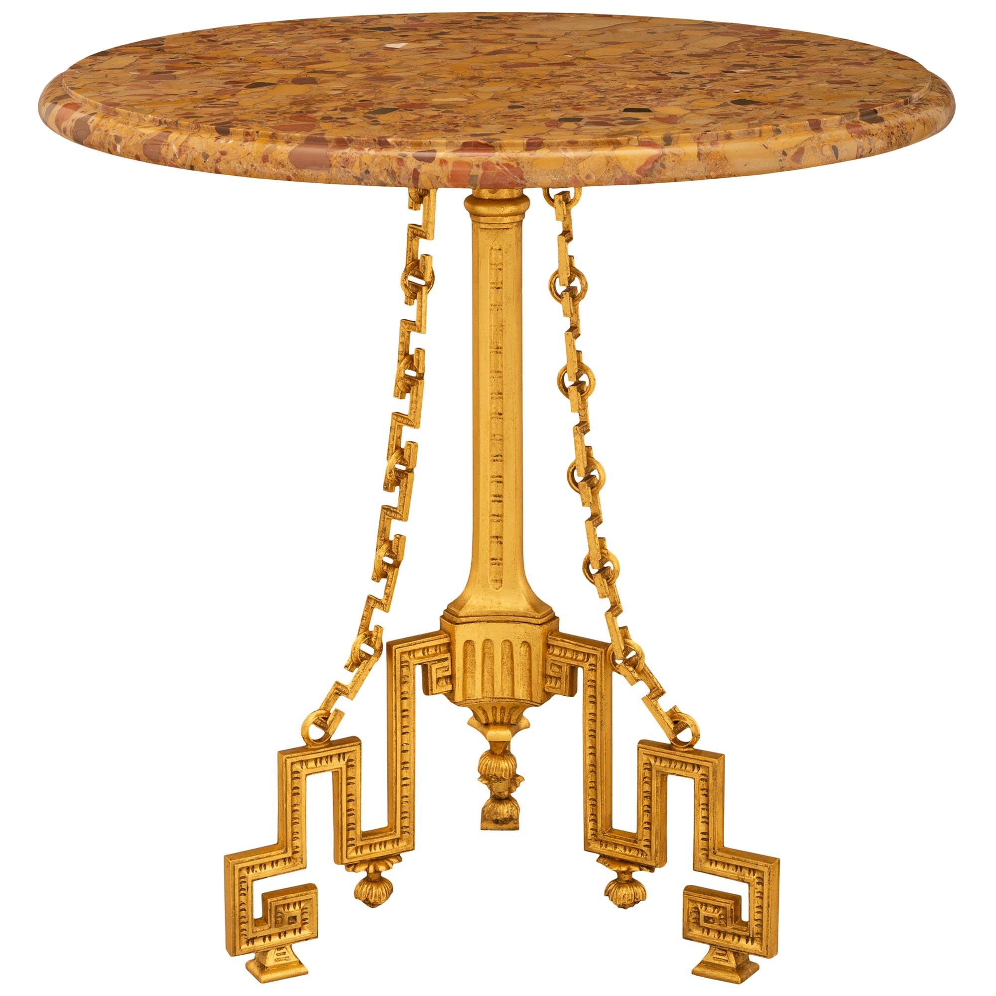 Superbe et unique table d'appoint Guéridon en bronze doré et marbre Brèche d'Alep de style Louis XVI du XIXe siècle. Cette superbe table est surélevée par trois pieds en bronze doré à clé grecque avec des supports carrés. Chaque pied présente un