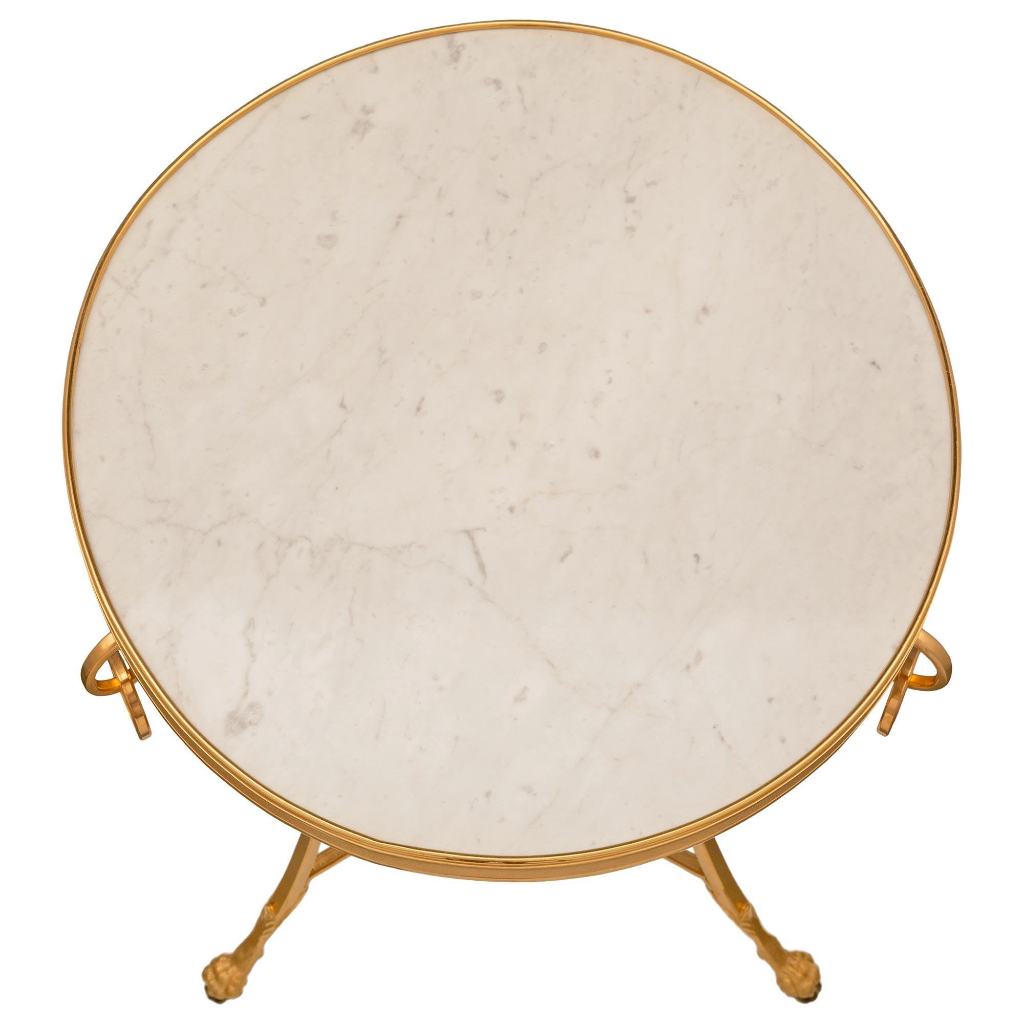 Ein eleganter und äußerst dekorativer französischer Beistelltisch aus Ormolu und weißem Carrara-Marmor aus dem 19. Jahrhundert. Der Tisch steht auf drei schönen, leicht geschwungenen Beinen mit reich ziselierten Tatzenfüßen, die mit feinen