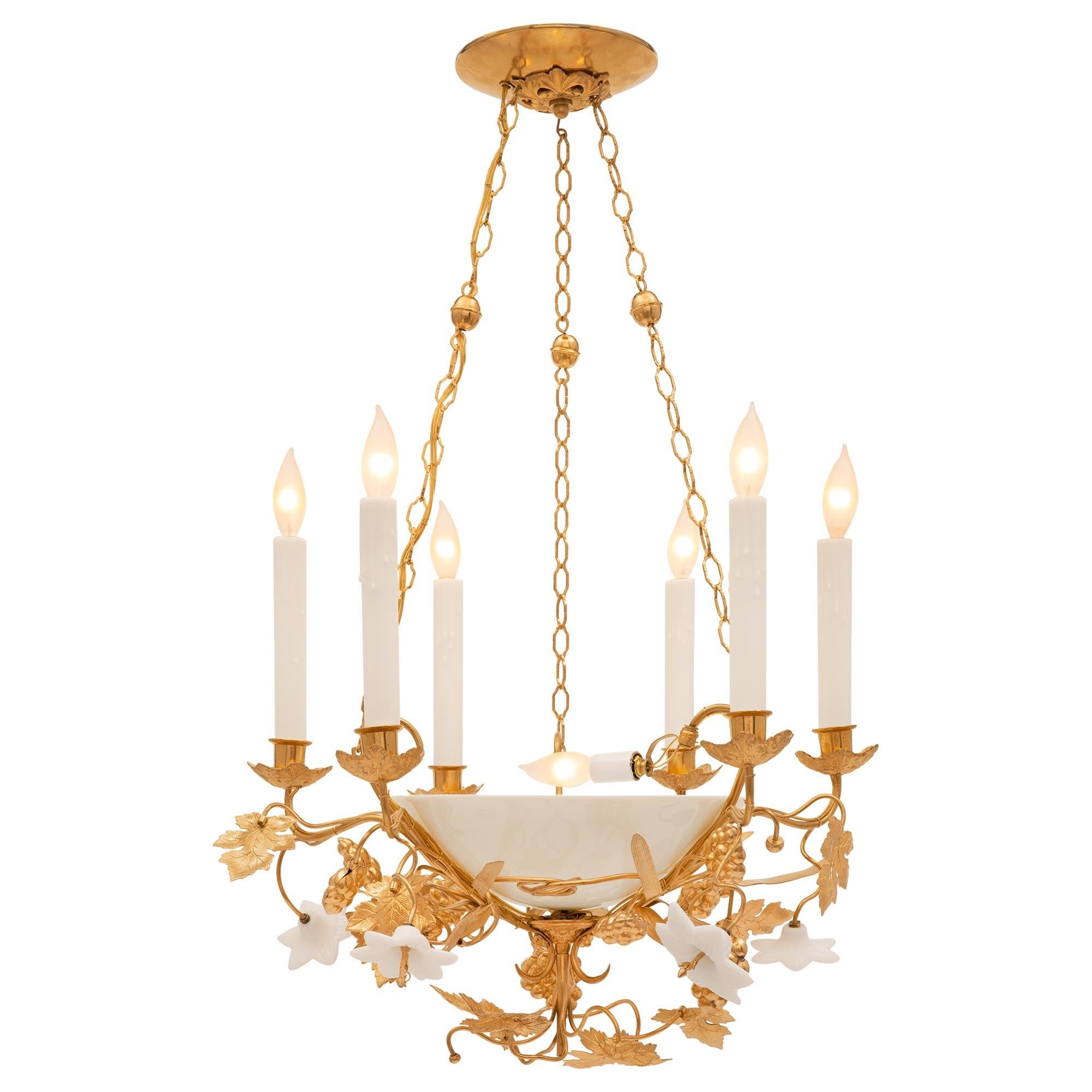 A unique and most decorative French 19th century Louis XVI st. ormolu and opaline chandelier. The six arm, seven bulb chandelier is centered by exquisite extremely decorative branch like designs with striking wonderfully executed leaves with fine