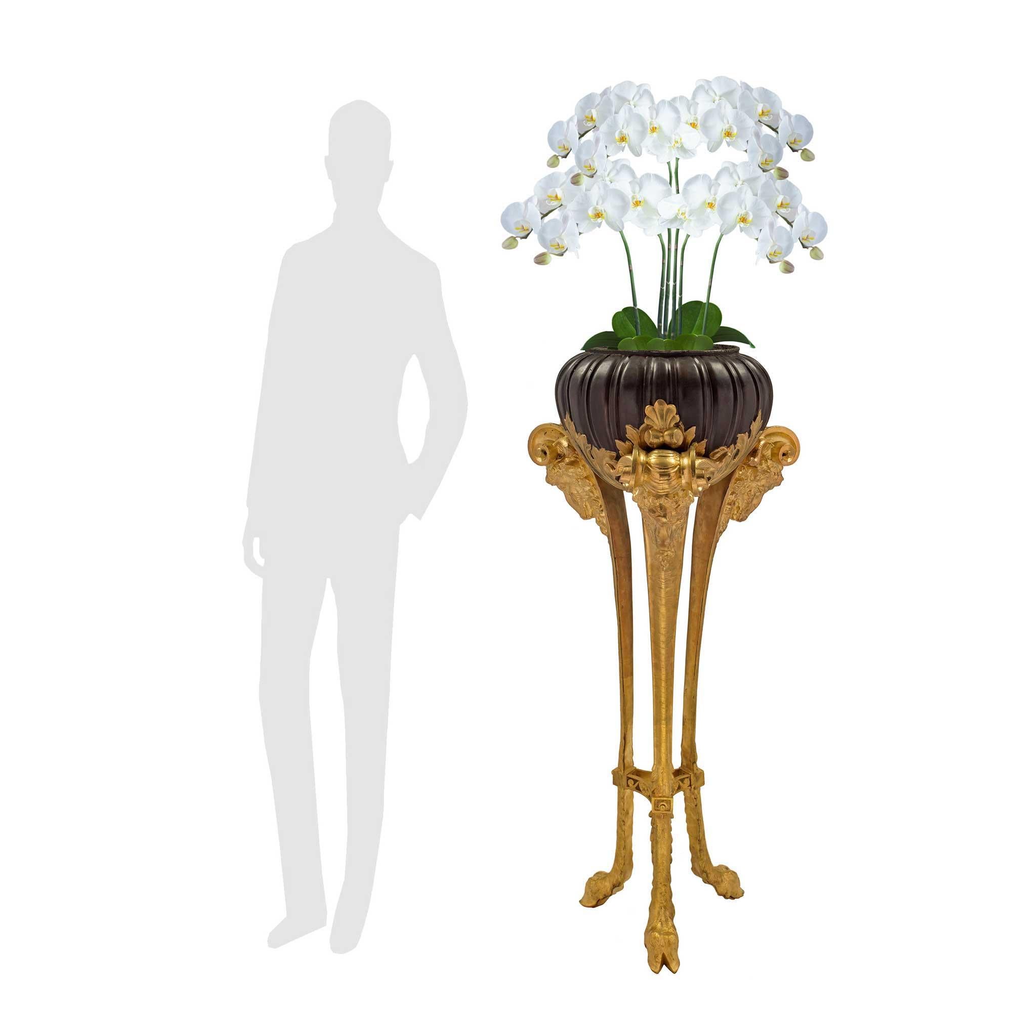 A handsome and most impressive large scale French 19th century Louis XVI st. ormolu and patinated bronze planter. The planter is raised by a most decorative tripod ormolu support with elegantly curved legs, superb hoof feet and a triangular concave