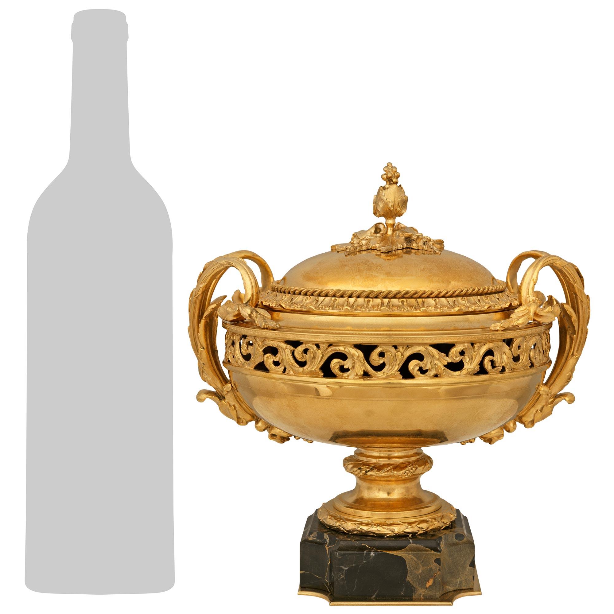 Une élégante urne en bronze doré et marbre Portoro de grande qualité, de style Louis XVI, datant du 19e siècle. Cette magnifique urne est surmontée d'une base carrée en marbre Portoro aux angles concaves et d'une fine plaque en bronze doré. Le socle
