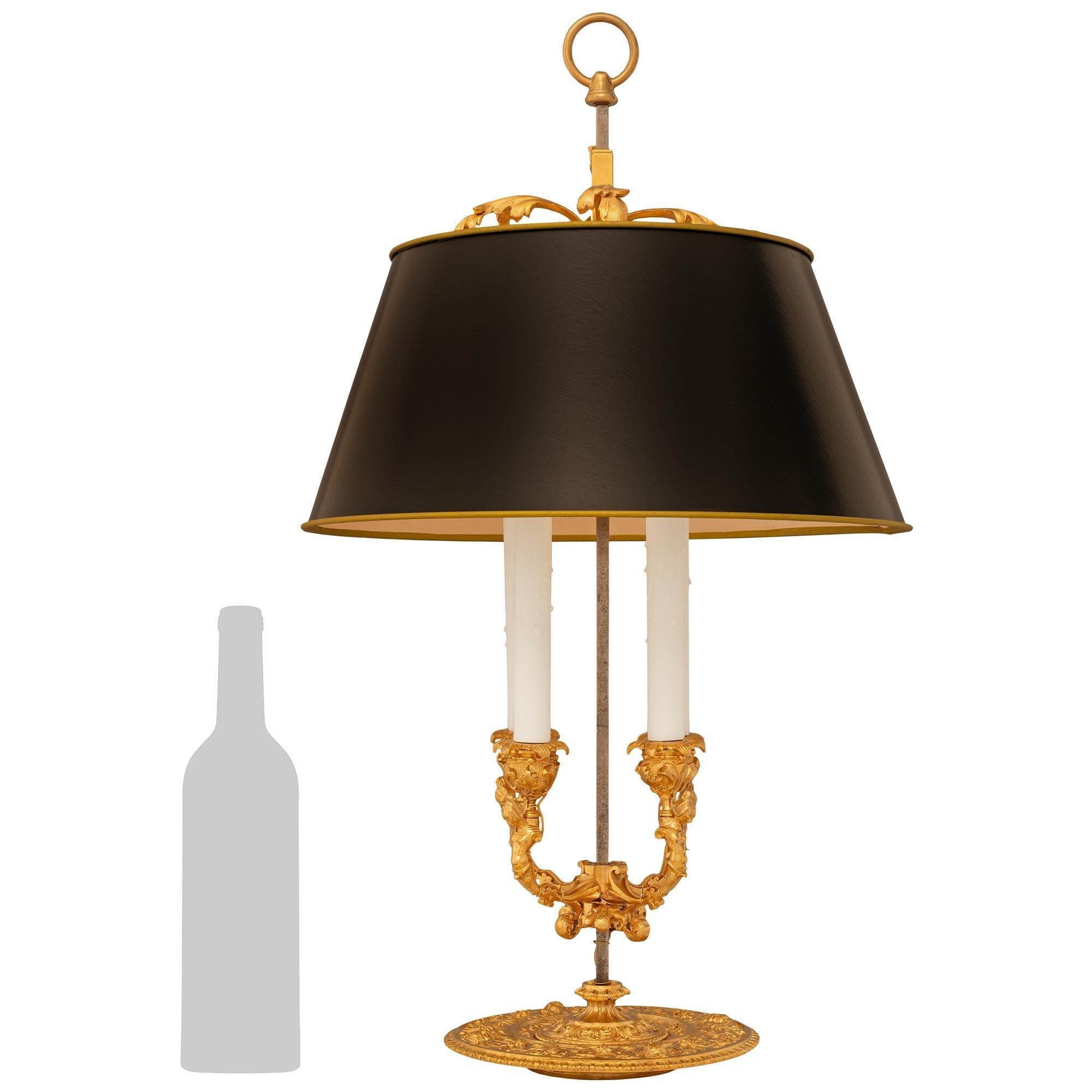 Lámpara francesa del siglo XIX de Ormolu y Tole Bouillotte, de estilo Luis XVI, muy decorativa y finamente detallada. Esta hermosa lámpara de cuatro brazos se apoya en una placa de base circular muy detallada, decorada con diseños de volutas