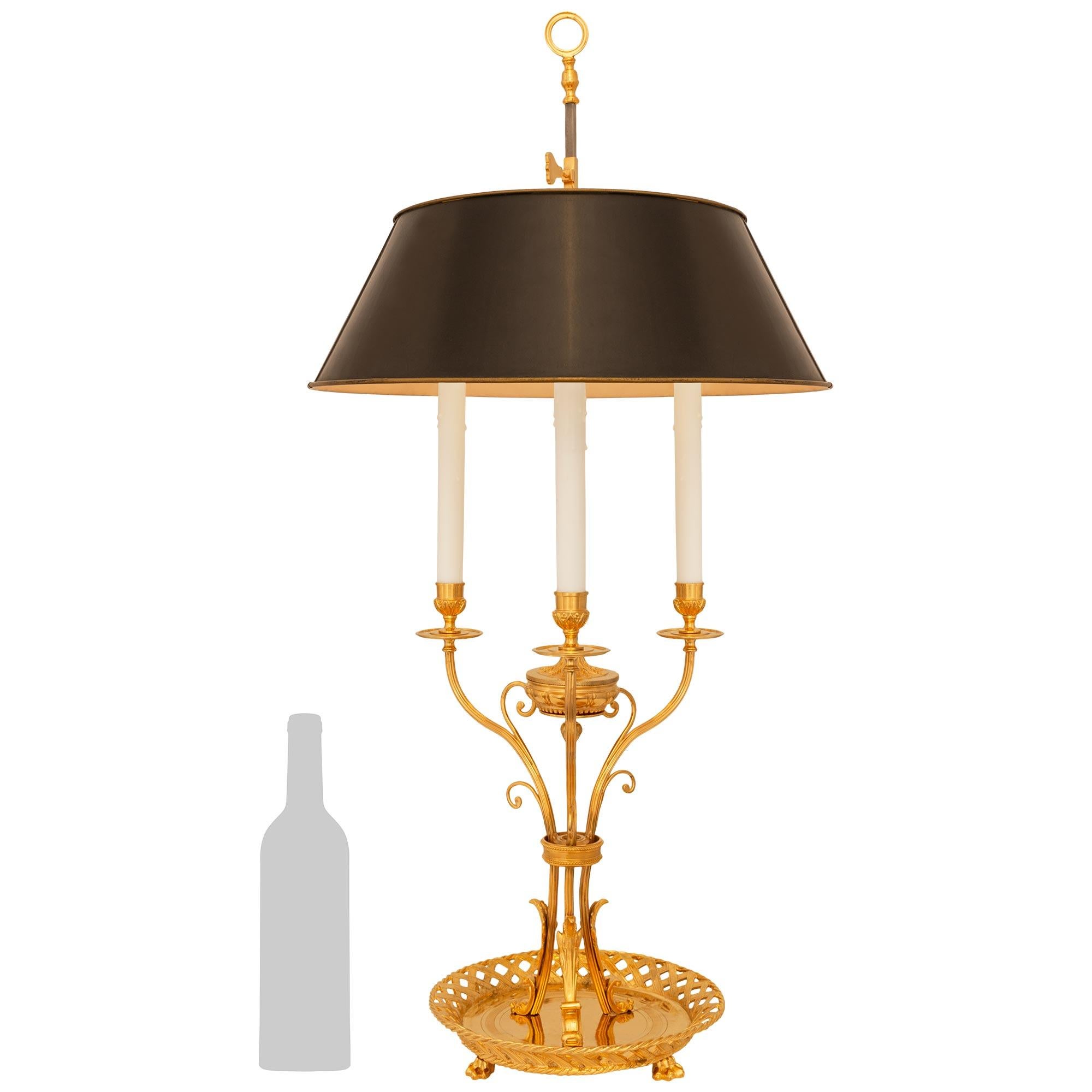 Un'attraente e molto decorativa lampada Bouillotte in ormolu e tole del XIX secolo. Questa squisita lampada a tre luci è sollevata da una bellissima ciotola circolare forata con bordi disegnati a torsione e sostenuta da quattro piedi a zampa. Al