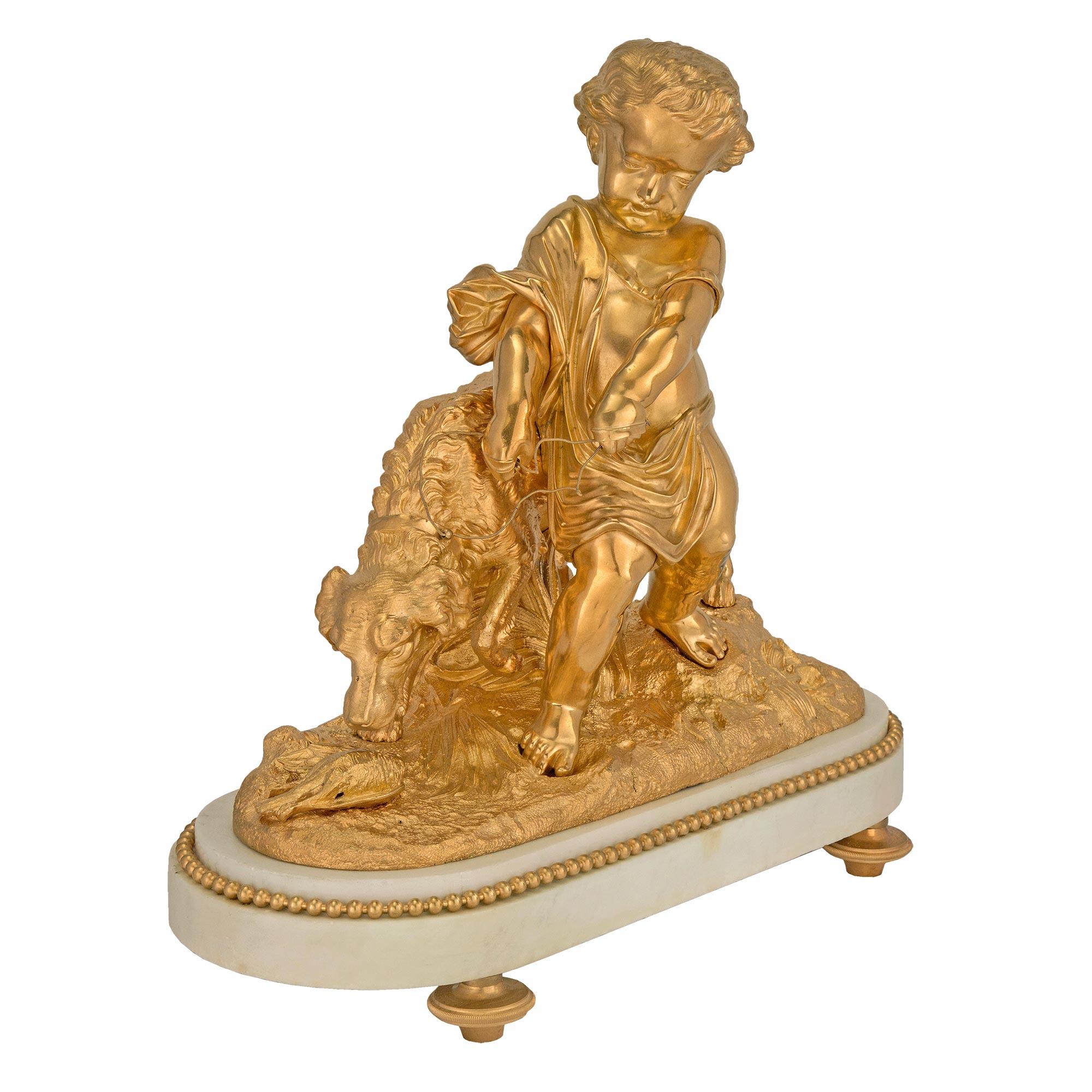 A high quality and charming French 19th century Louis XVI St. ormolu and White Carrara marble statue. Raised by a thick oval white Carrara marble base with ormolu topic shaped feet and a mottled top with a fitted beaded ormolu trim. The ormolu