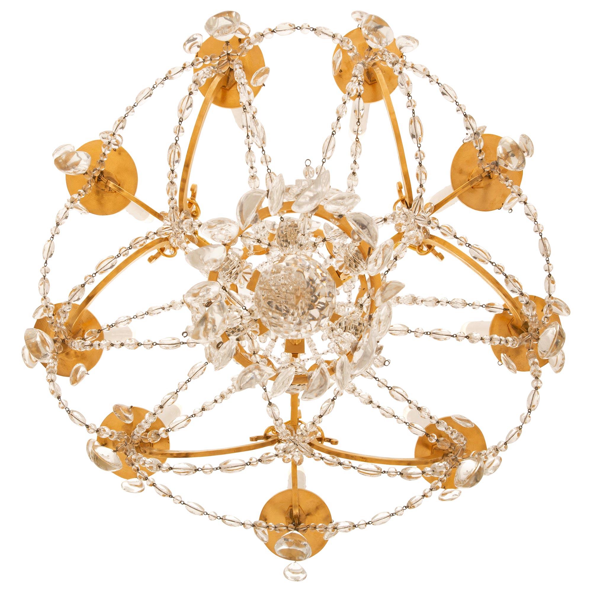 A stunning French 19th century Louis XVI st. Ormolu and Baccarat Marie Antoinette chandelier. This nine arm Marie Antoinette style chandelier is centered by a spectacularly cut Baccarat Crystal ball surrounded by a ring of tear drop shaped Crystals