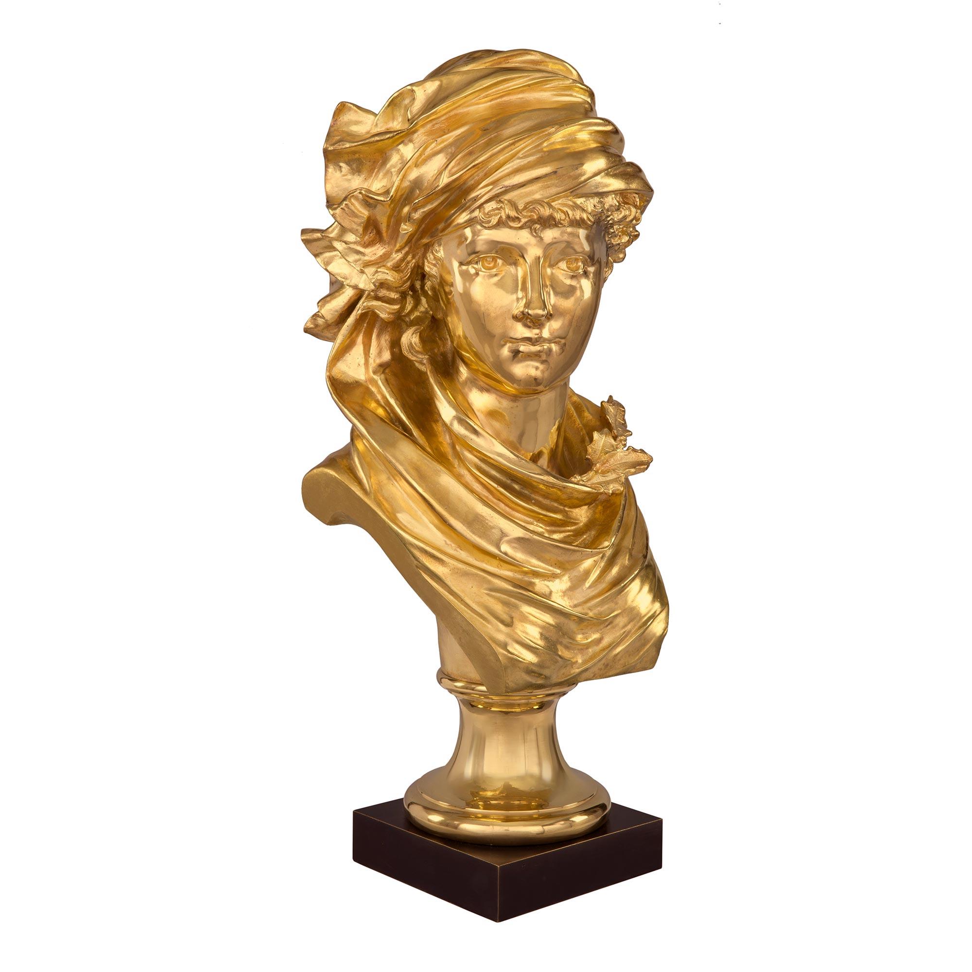 Auffällige französische Ormolu-Büste eines jungen Mädchens aus dem 19. Jahrhundert, signiert A. Rollé. Die Büste steht auf einem quadratischen Sockel aus patinierter Bronze unter einem runden Sockel aus Ormolu mit einer gesprenkelten Umrandung. Das