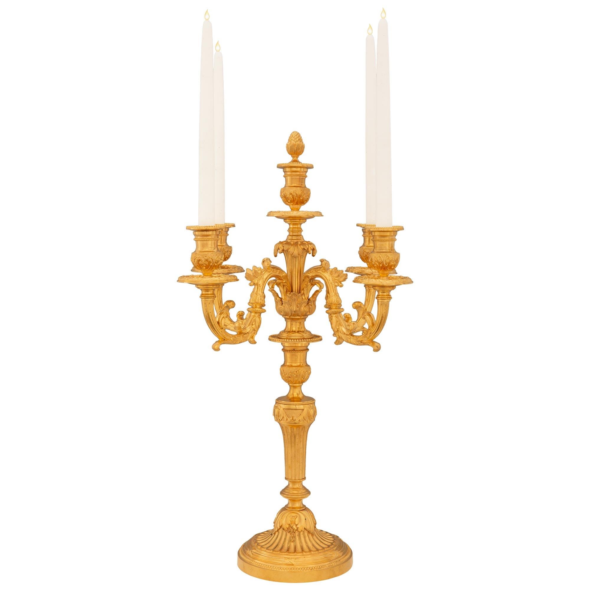 Un elegante candelabro francese di alta qualità del XIX secolo in stile Luigi XVI. Ciascun candelabro a cinque bracci è sollevato da una base circolare screziata con raffinati disegni di perline e scanalature legate. Il supporto del piedistallo a