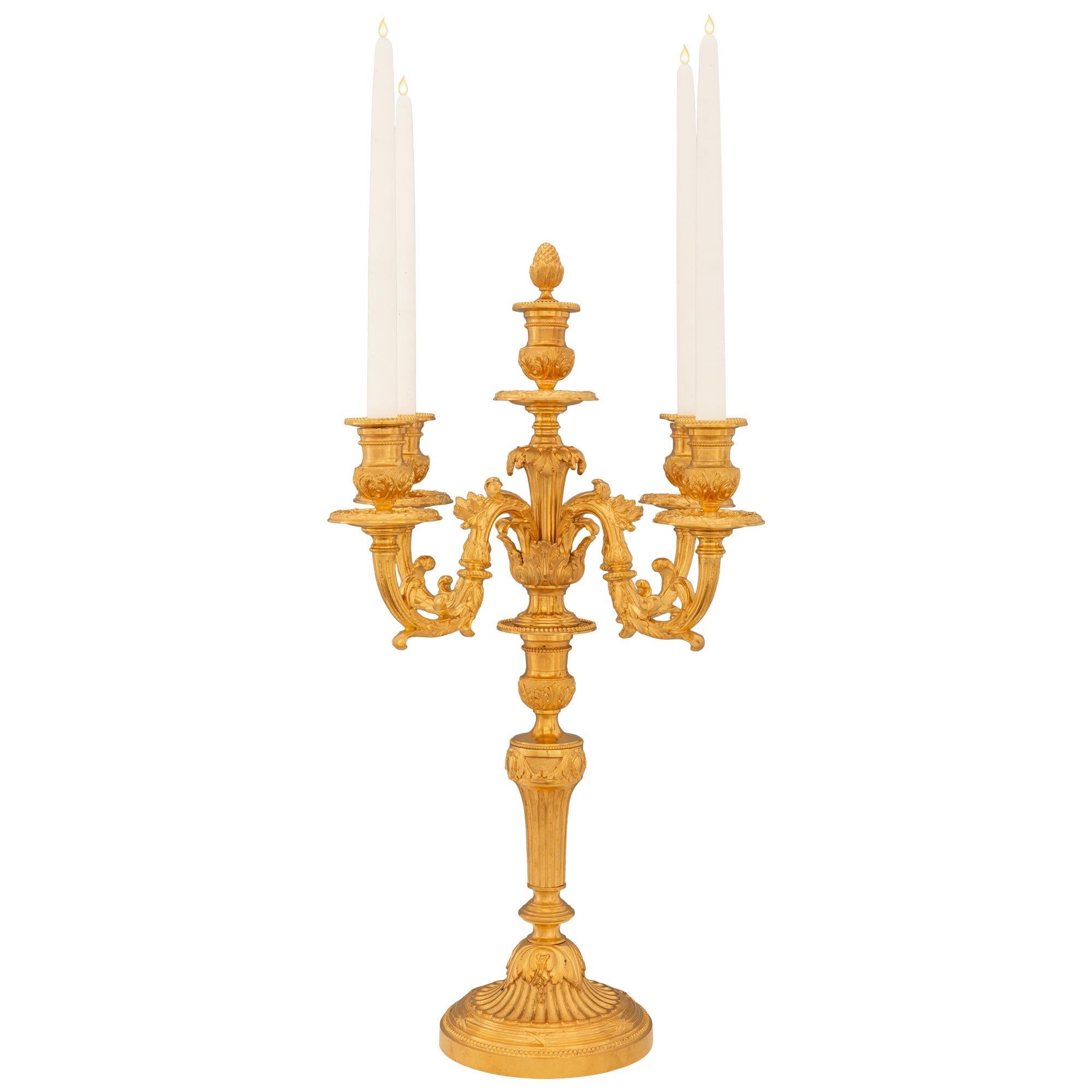 An elegant and very high quality French 19th century Louis XVI st. ormolu candelabras. Each five arm candelabra is raised by a circular mottled base with fine wrap around beaded and tied fluted designs. The socle shaped pedestal support displays a