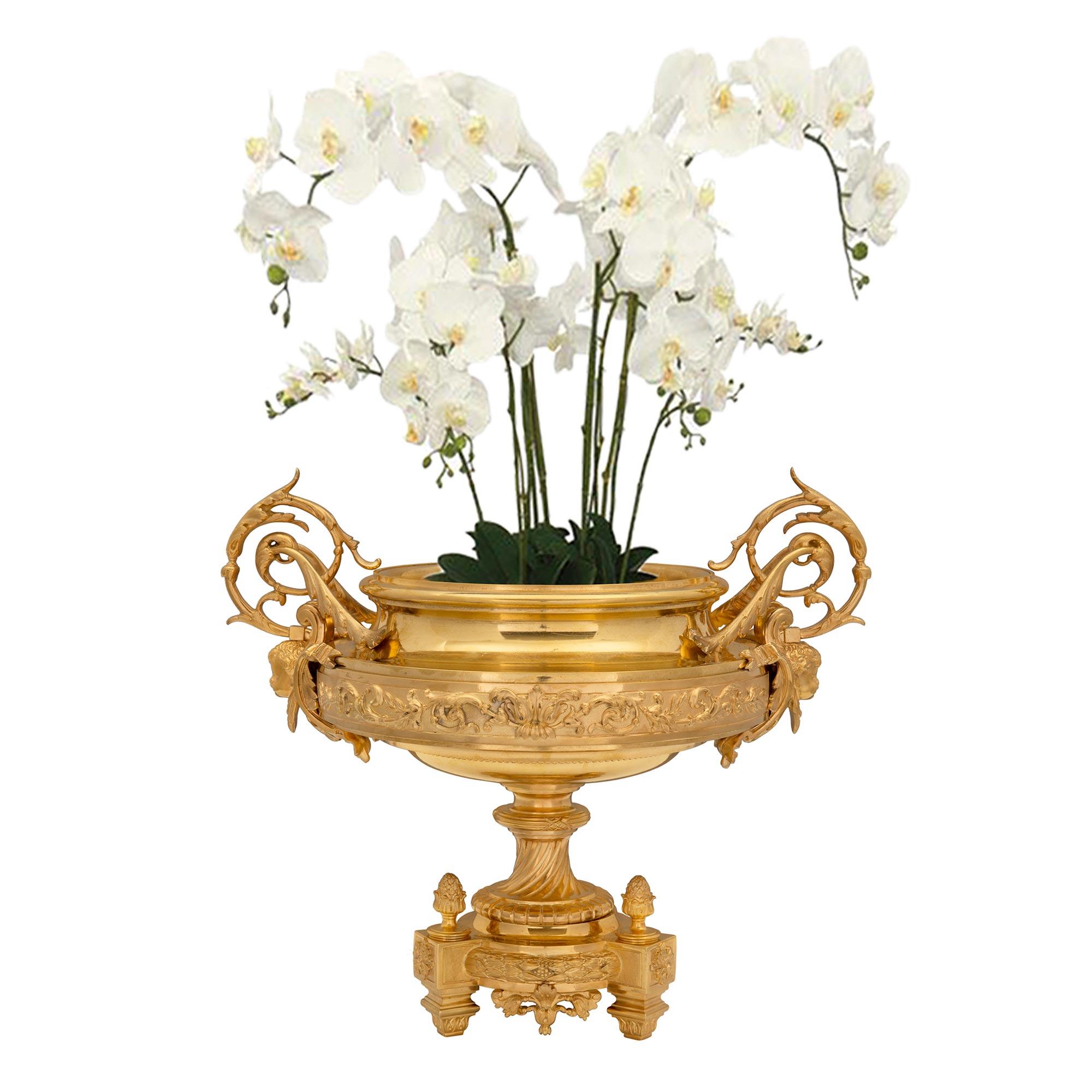A most elegant and high quality French 19th century Louis XVI style ormolu centerpiece. The centerpiece is raised by square foliate feet below charming block rosettes and beautiful acorn finials flanked by fine foliate movements. A detailed berried