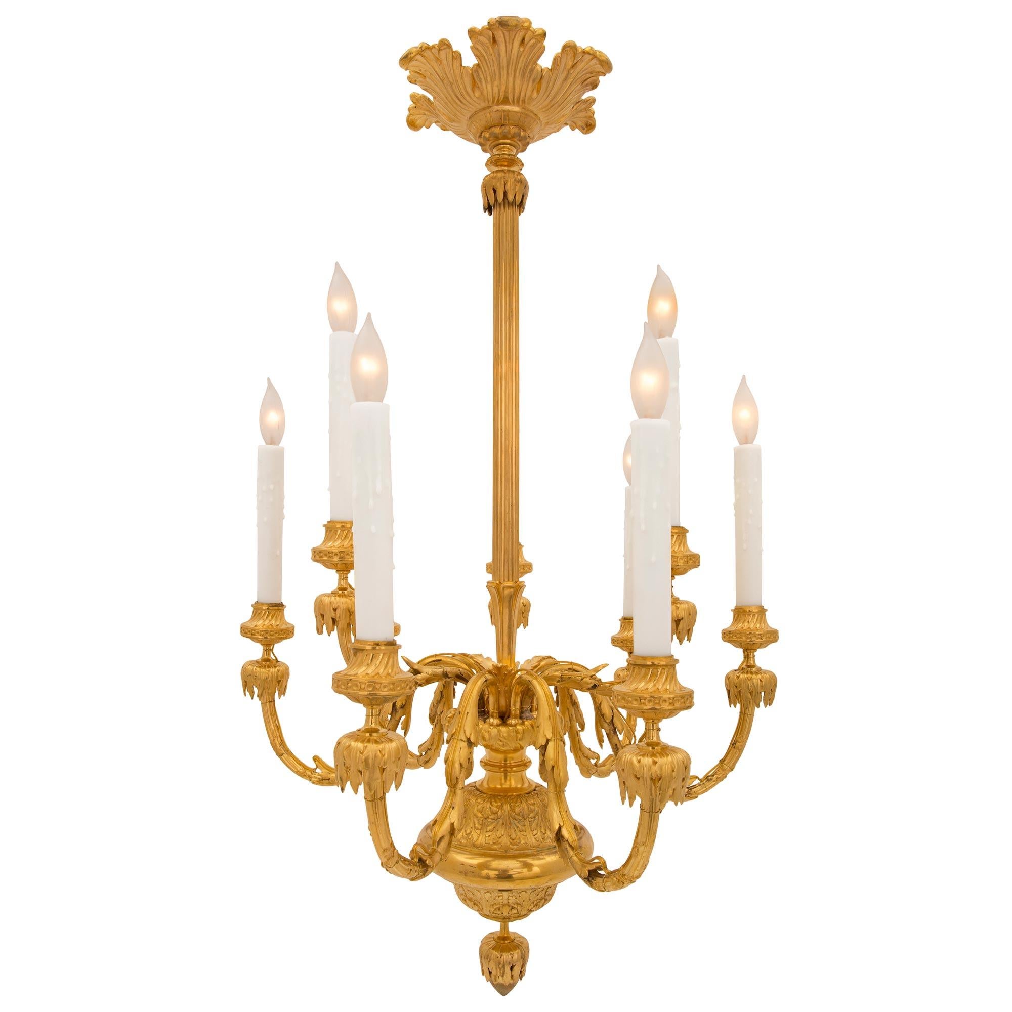 An elegant and extremely decorative French 19th century Louis XVI st. ormolu chandelier. The nine arm chandelier is centered by a beautiful inverted bottom acorn finial amidst outstanding richly chased acanthus leaf patterns. Each elegantly scrolled