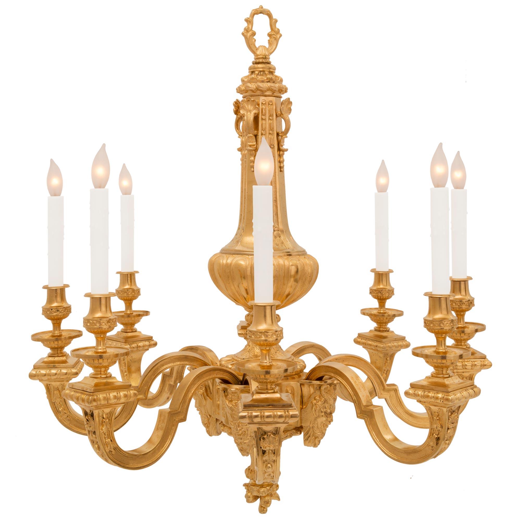 An exceptional French 19th century Louis XVI st. ormolu chandelier. The eight arm chandelier is centered by a beautiful richly chased bottom floral finial below the elegantly curved support with fine foliate details. The arms branch out from