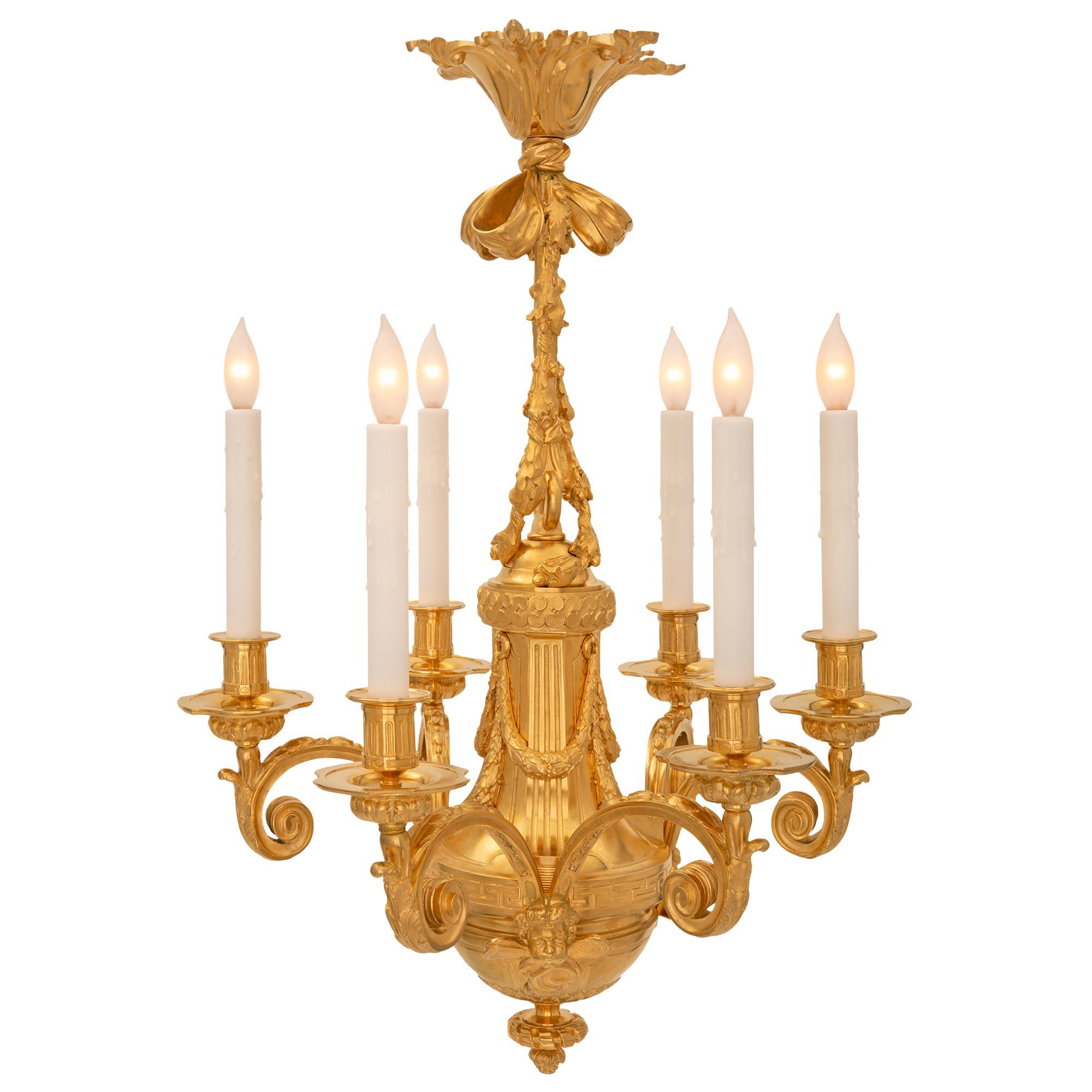 A superb French 19th century Louis XVI st. ormolu chandelier. The six arm chandelier is centered by an elegant bottom acorn shaped and twisted ribbon finial below the dome shaped body. Three pairs of elegantly scrolled arms branch out from charming