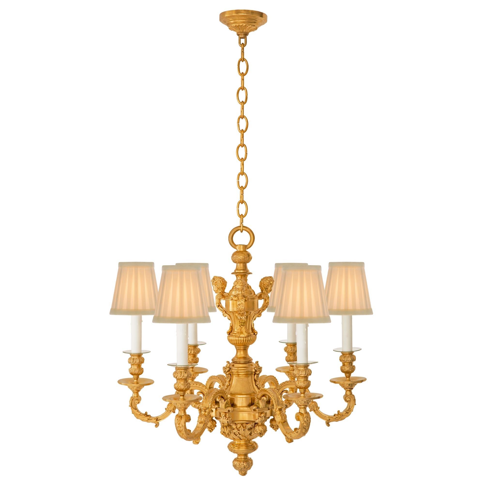 An exceptional French 19th century Louis XVI st. ormolu chandelier. The six arm chandelier is centered by a beautiful richly chased foliate finial below an elegant mottled tied reeded band and stunning foliate designs. Each scrolled arm displays a