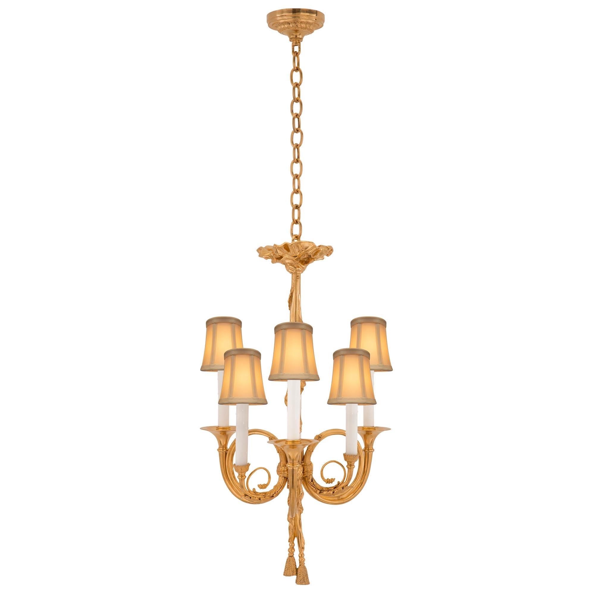 A beautiful French 19th century Louis XVI st. ormolu chandelier. The six arm chandelier is centered by charming finely detailed tied tassels below a wonderfully executed draped theatrical curtain like design. At the center are three scrolled French