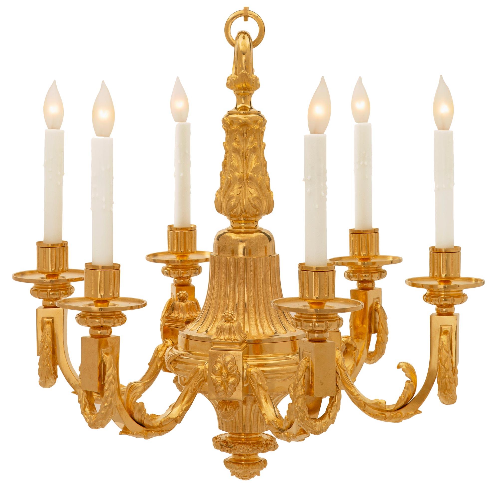 A beautiful and high quality French 19th century Louis XVI st. ormolu chandelier. The six arm chandelier is centered by a lovely bottom foliate finial below the elegantly tapered fluted body. The three pairs of arms branch out from richly chased