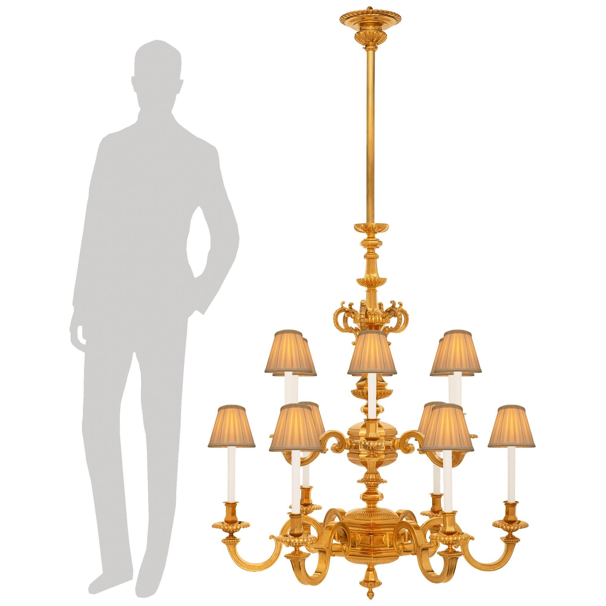 Un lampadario monumentale e di alta qualità in Ormolu francese del XIX secolo Luigi XVI. Questo lampadario a dodici bracci e dodici luci di grandi dimensioni è centrato da un finale esagonale a forma di topie che pende da un livello inferiore con un