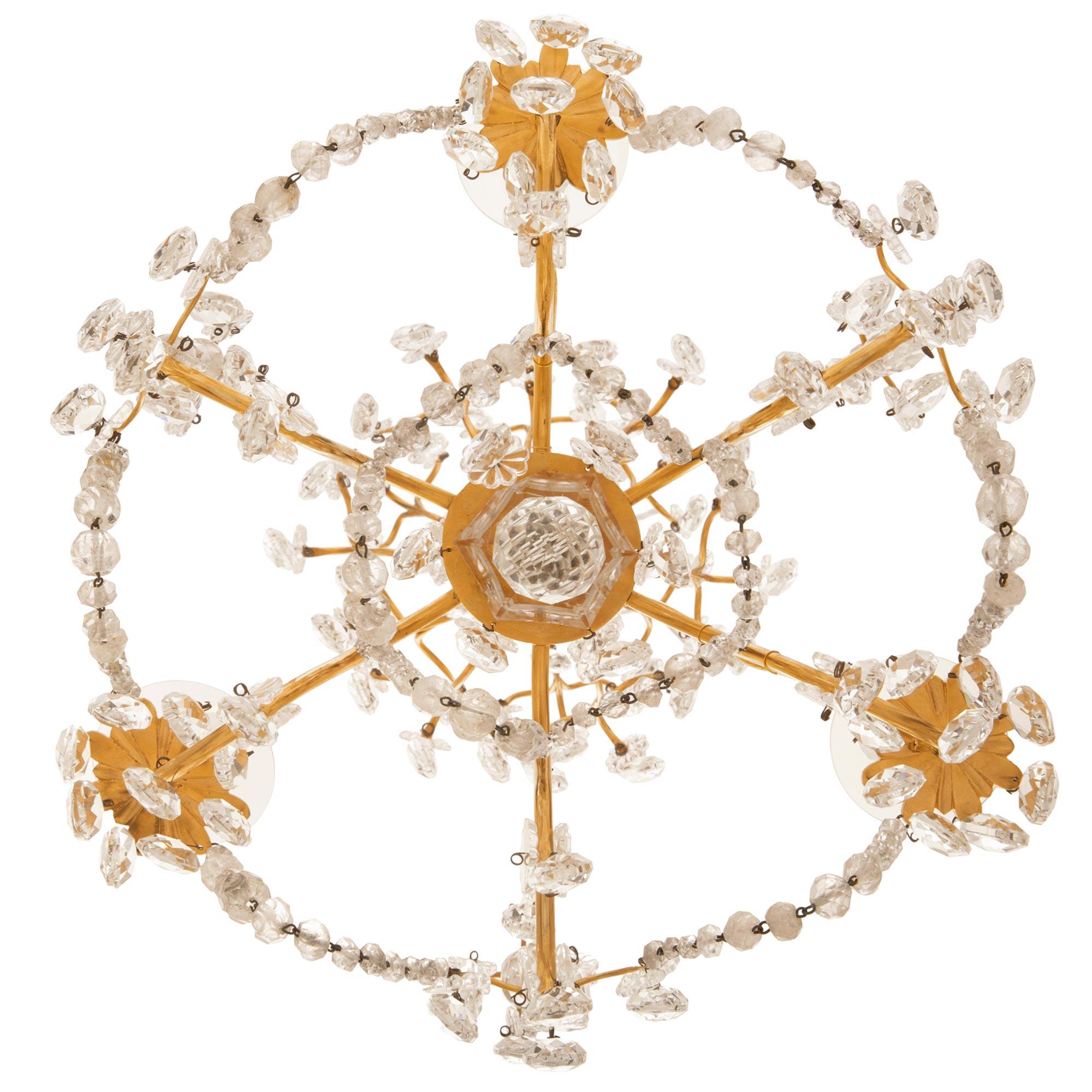 A charming and small scale French early 19th century Louis XVI st. Ormolu, Crystal and Rock Crystal chandelier. The six arm chandelier is centered by a fine bottom facetted cut crystal ball below a lovely Crystal fut from where the arm branch out.