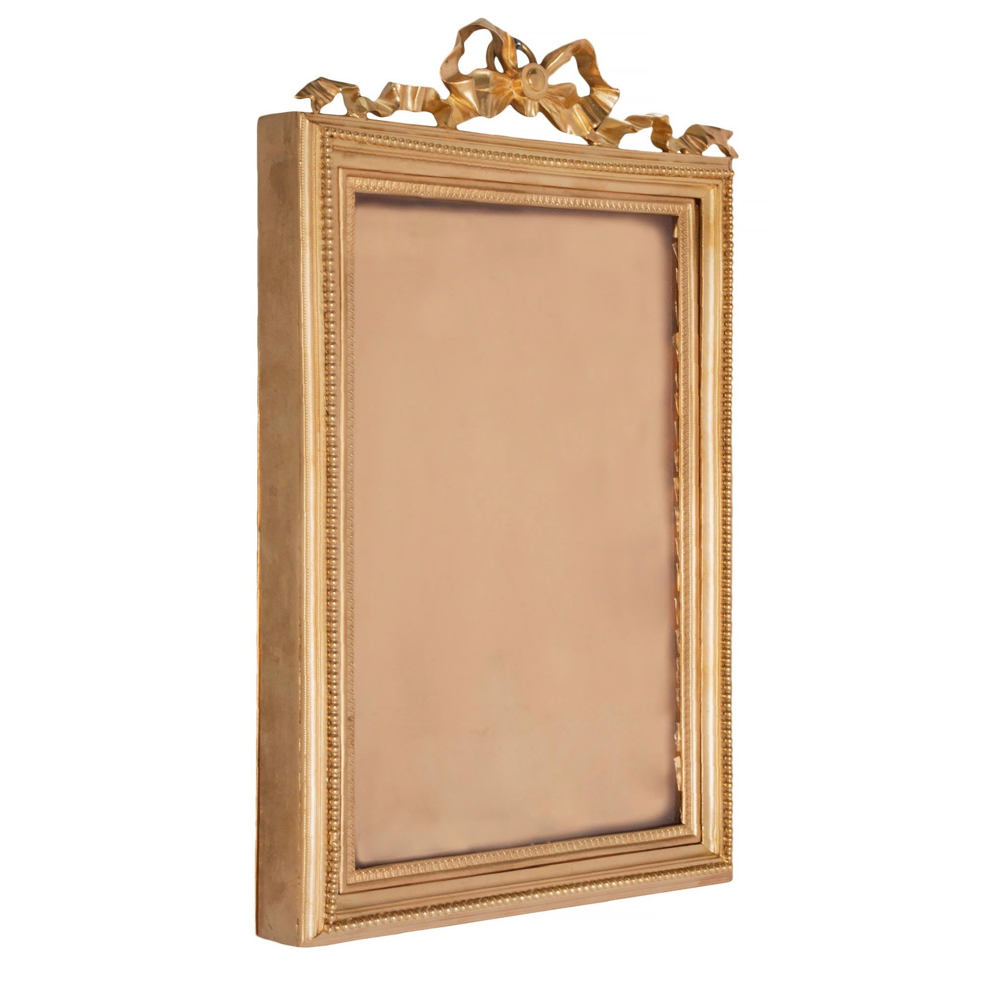 Un'elegante cornice francese del XIX secolo in stile Luigi XVI con ormeggio. La cornice rettangolare mostra la lastra di vetro originale incorniciata da un motivo Coeur de Rai finemente cesellato e da un disegno a perline. In cima c'è un