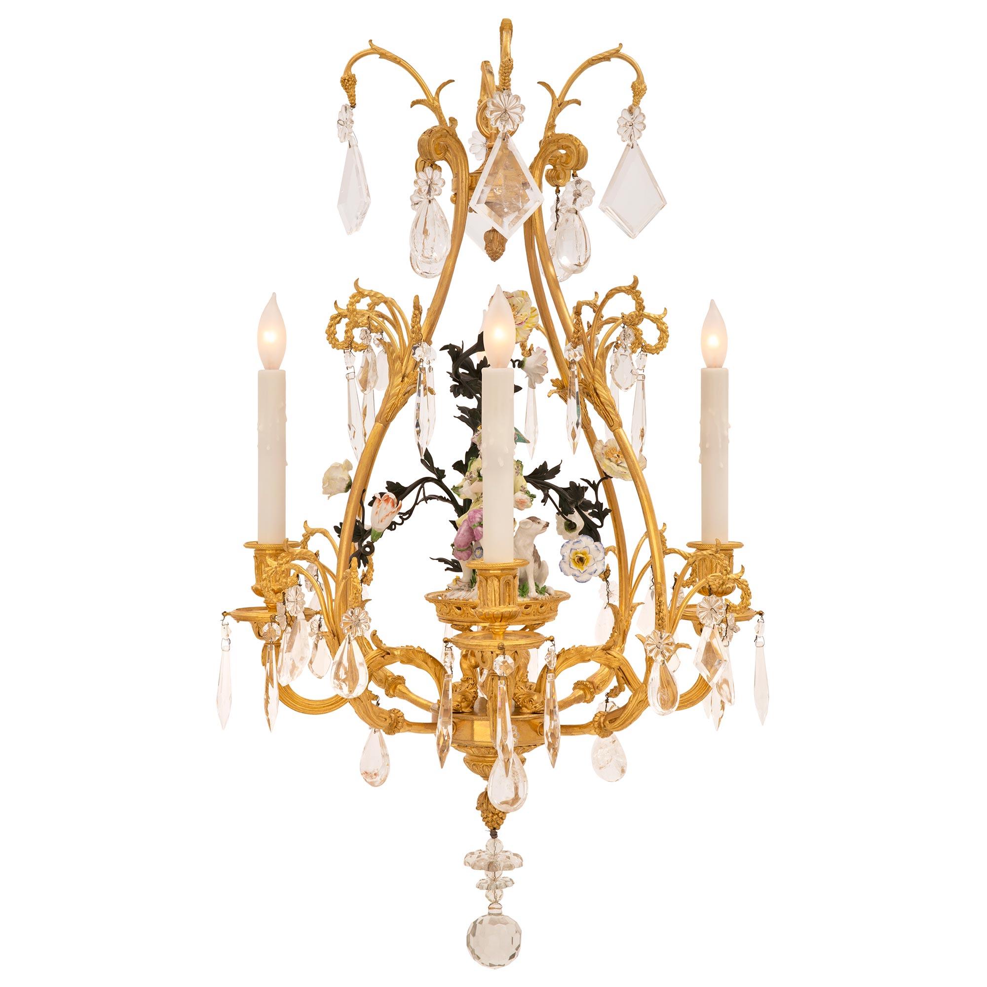 A beautiful and most charming French 19th century Louis XVI st. ormolu, Meissen porcelain, crystal and rock crystal chandelier. The chandelier is centered by an elegant cut crystal ball pendant below lovely rosettes and a finely detailed bottom