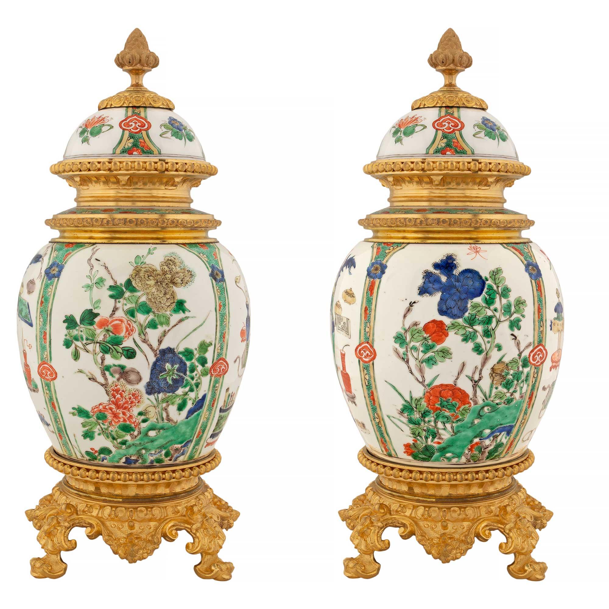 A very fine pair of 19th century Chinese Export porcelain lidded urns on French Louis XVI st. ormolu mounts. Each urn is raised by circular ormolu bases with scrolled supports below an elegant beaded band. Above is the handsome urn with floral