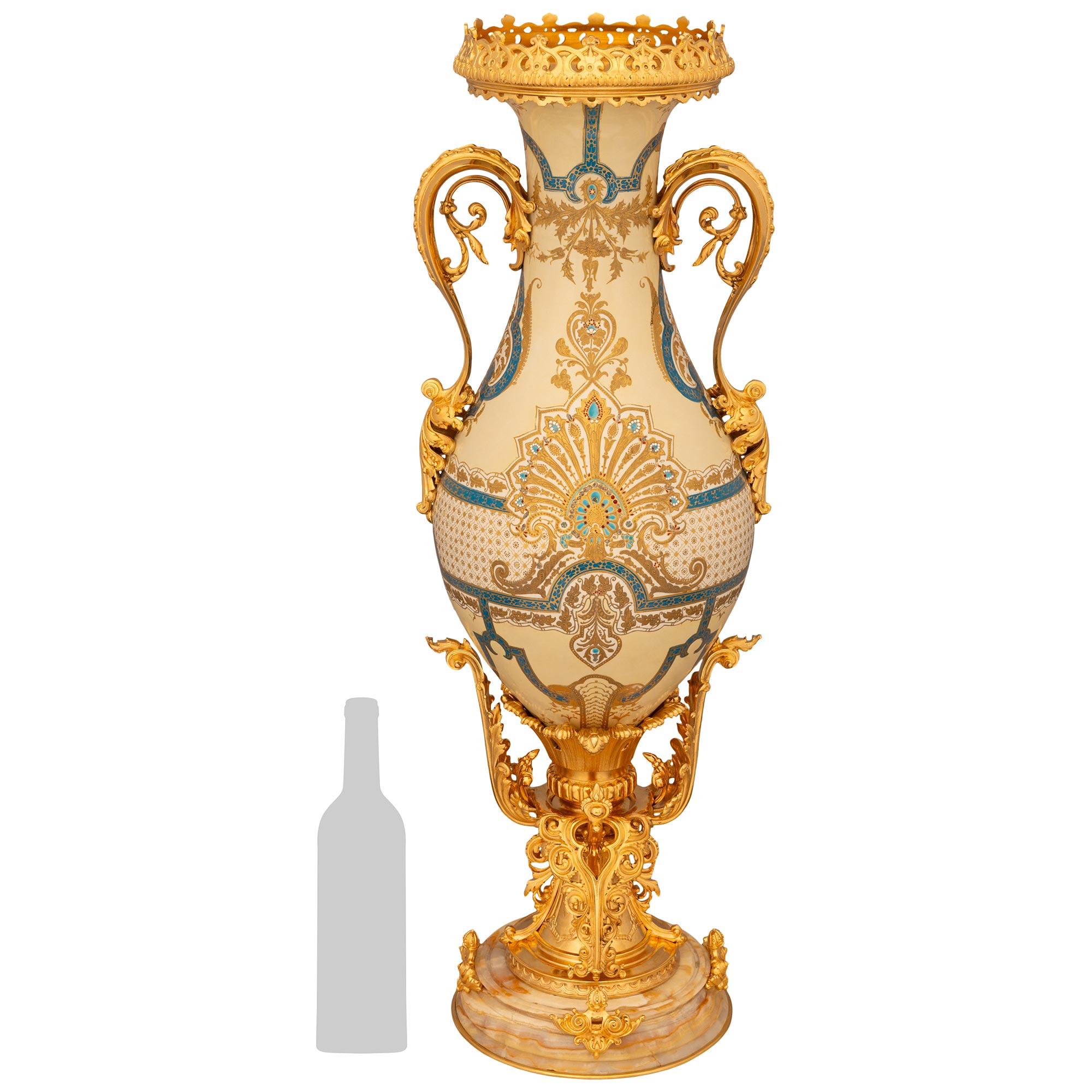 Un vaso francese del XIX secolo Luigi XVI, in ormolu, porcellana e onice, di dimensioni monumentali e di grande effetto. Questo vaso di grande impatto visivo poggia su uno zoccolo in Ormolu traforato di alta qualità che mostra foglie d'acanto a