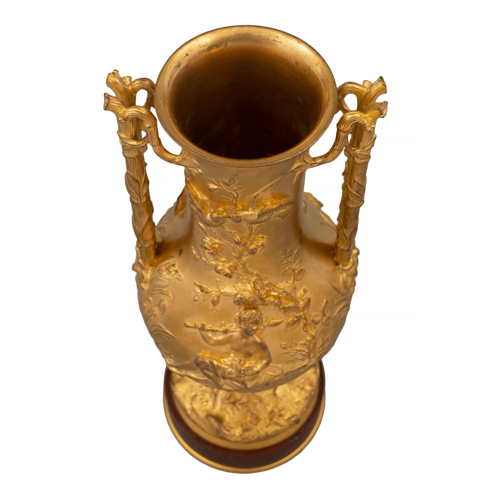 Deliziosa urna francese del XIX secolo in marmo e ormolu di epoca Luigi XVI, firmata 'F. Barbedienne'. L'urna è sollevata da una base circolare in marmo Rouge Griotte con un filetto inferiore in ormolu. Alla base dell'urna in ormolu c'è un disegno