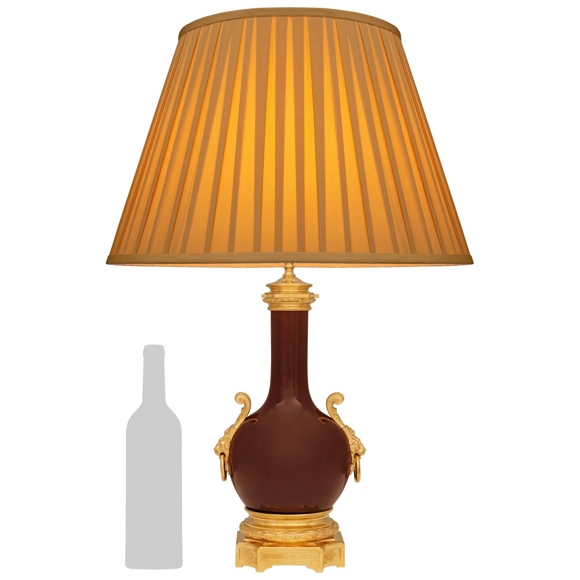 Un'elegante e unica lampada francese del XIX secolo in porcellana color sangue di bue e ormeggio. Questa splendida lampada poggia su una base ottagonale in Ormolu con angoli concavi e riserve geometriche finemente cesellate, centrate da rosette e