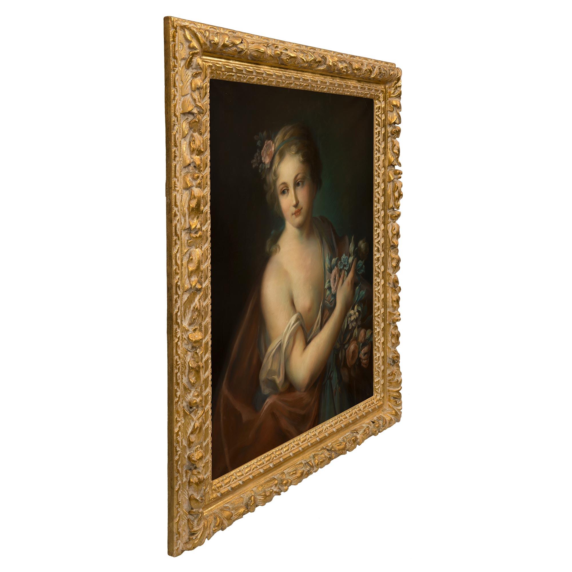 A most charming and finely detailed French 19th century Louis XVI st. pastel, in the manner of François Boucher. The pastel is framed within its original giltwood border with richly carved foliate, floral and twisted ribbon designs. The lovely