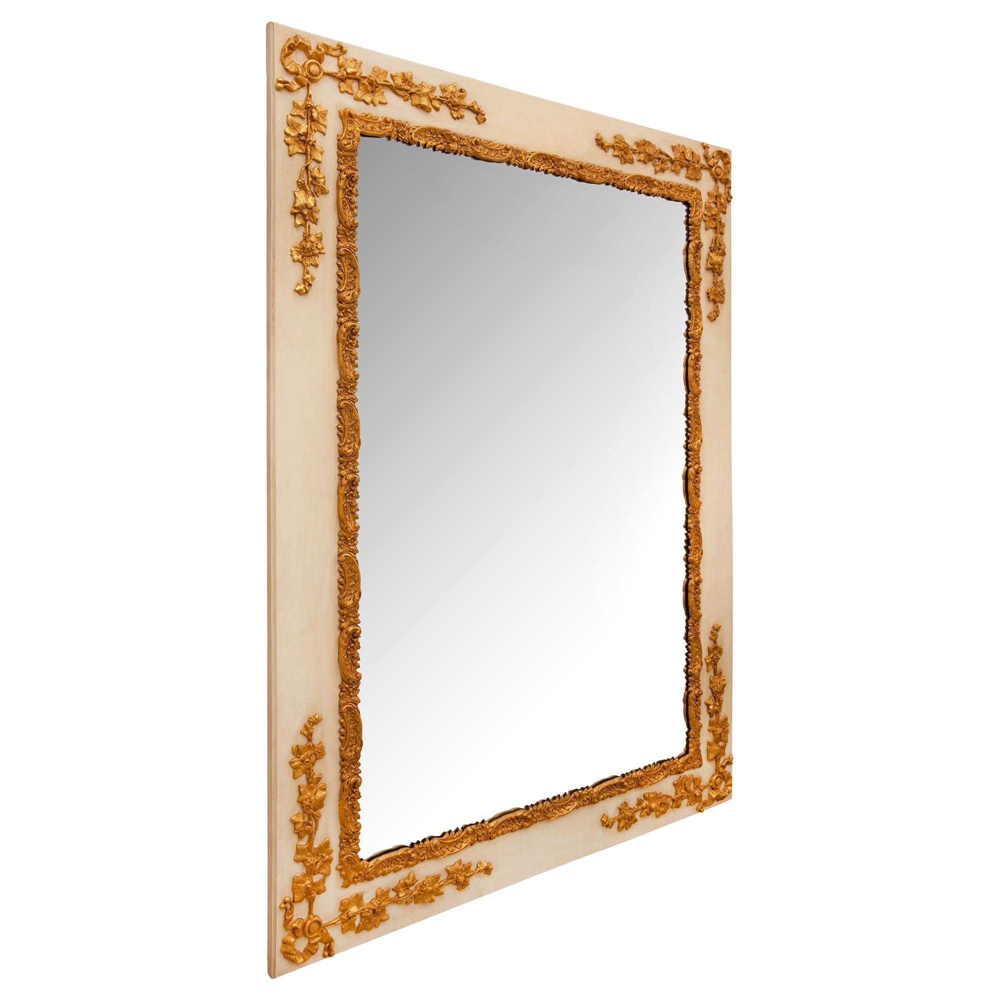 A striking and most unique French 19th century Louis XVI st. patinated and giltwood mirror. The mirror retains its original mirror plate framed within a beautiful richly carved giltwood frame with charming intricately detailed blooming flowers set