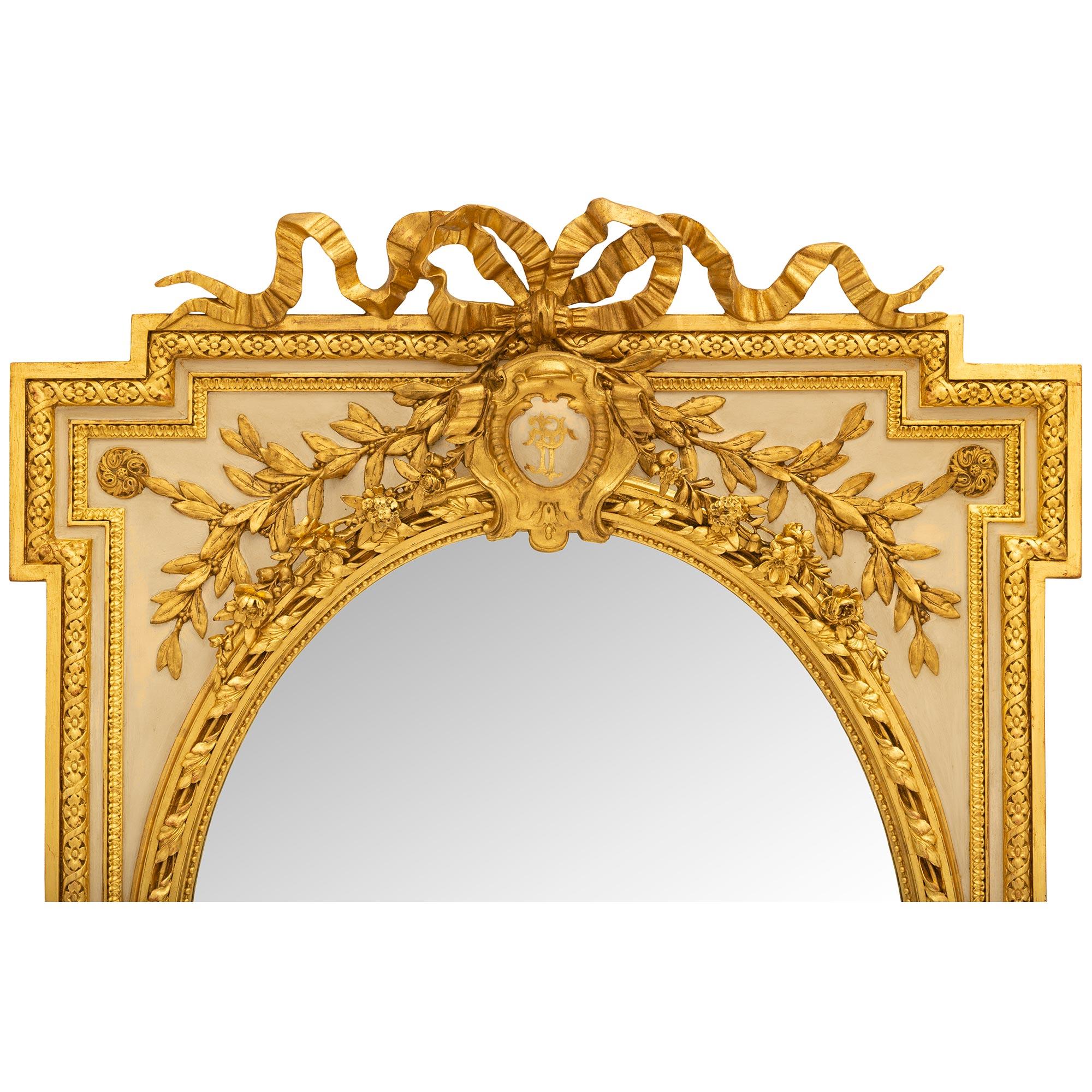 A stunning French 19th century Louis XVI st. Patinated and Giltwood mirror. The original oval mirror is framed within a beaded inner frame with an outer twisted foliate designed band. Below the oval mirror are two scrolled acanthus leaf Giltwood